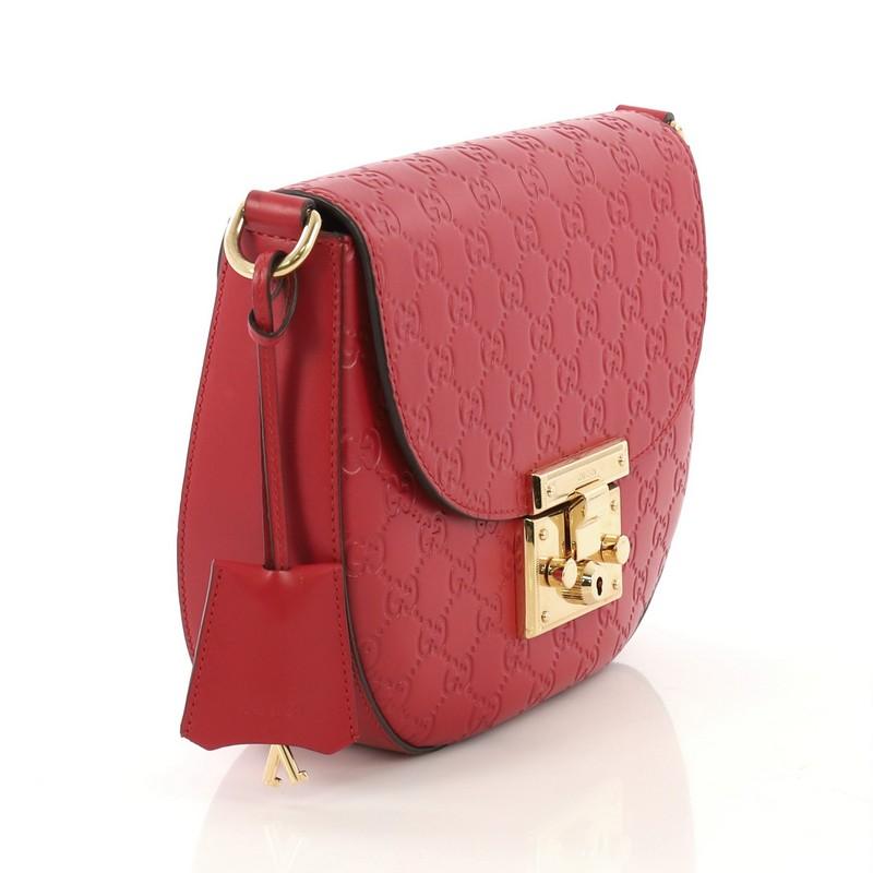 This Gucci Padlock Saddle Shoulder Bag Guccissima Leather Medium, crafted from red guccissima leather, features detachable adjustable web strap and gold-tone hardware. Its push clasp closure opens to a beige microfiber interior with slip