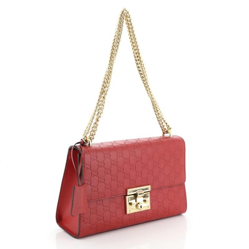 This Gucci Padlock Shoulder Bag Guccissima Leather Medium, crafted in red guccissima leather, features chain link strap, exterior card slip pocket, and gold-tone hardware. Its push-lock closure opens to a neutral microfiber interior with side zip