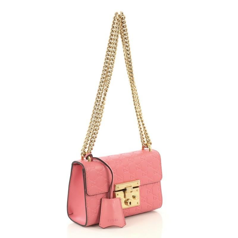 This Gucci Padlock Shoulder Bag Guccissima Leather Small, crafted in pink guccissima leather, features chain link strap, exterior card slip pocket, and gold-tone hardware. Its push-lock closure opens to a neutral microfiber interior with side slip
