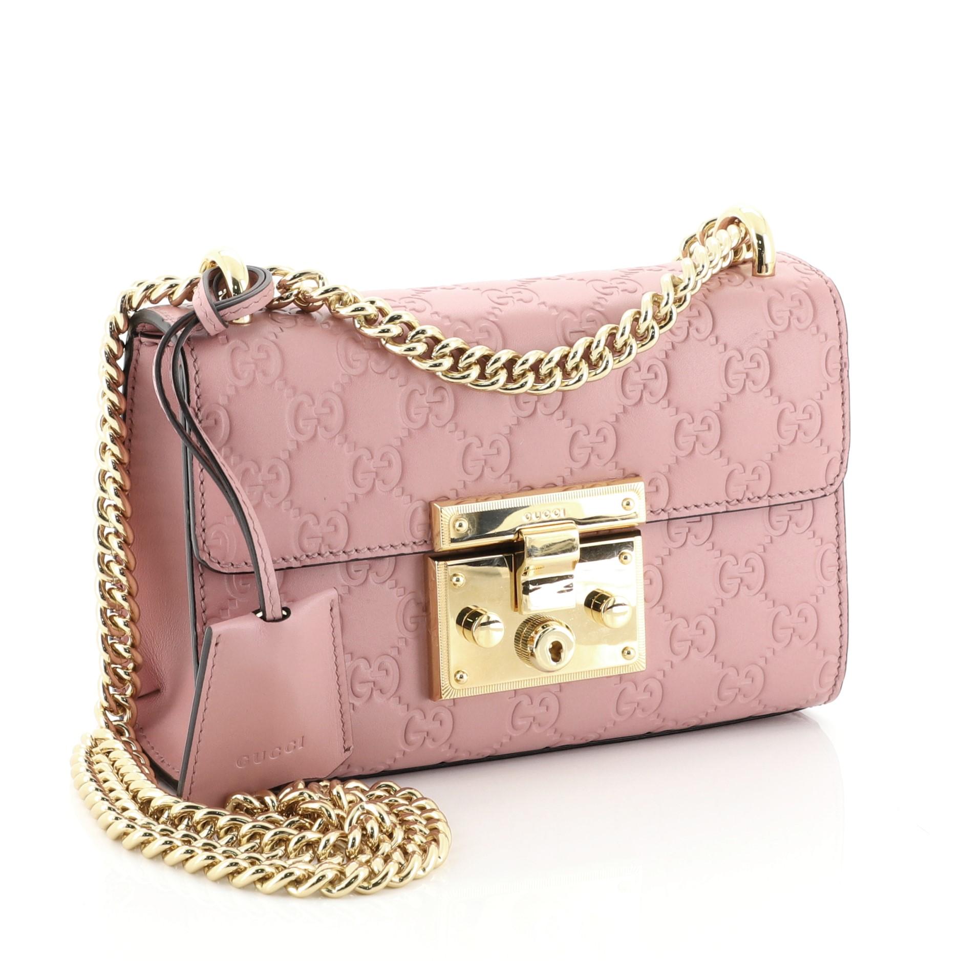 This Gucci Padlock Shoulder Bag Guccissima Leather Small, crafted in pink guccissima leather, features chain link strap, exterior card slip pocket, and gold-tone hardware. Its push-lock closure opens to a neutral microfiber interior with side slip