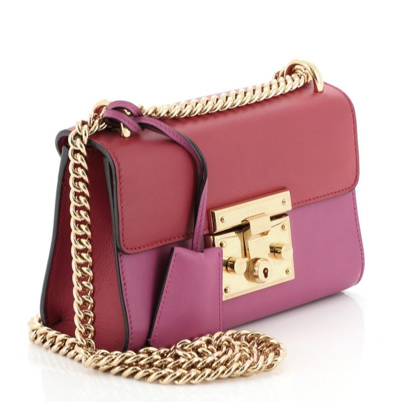 This Gucci Padlock Shoulder Bag Leather Small, crafted in pink and red leather, features chain link strap, exterior back card pocket, and gold-tone hardware. Its padlock push-lock closure opens to a neutral microfiber interior with slip pocket. 