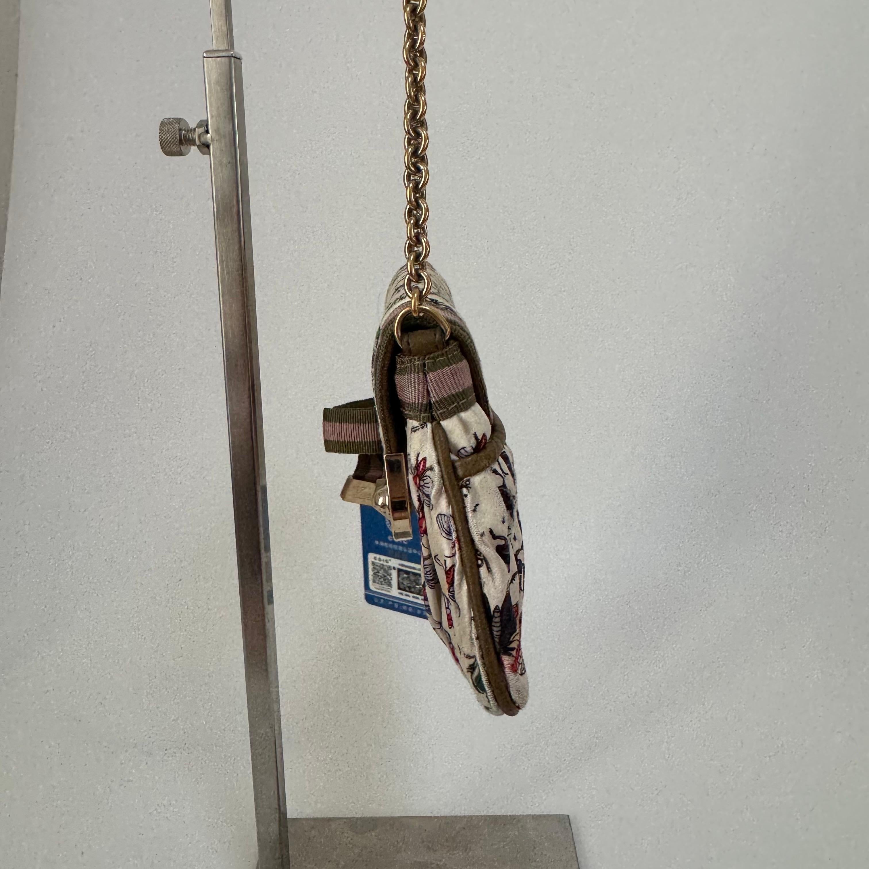 This compact Gucci padlock shoulder chain bag serves as a charming accessory. Made with a variety of floral silk patterns, it features the iconic Gucci web motif and a decorative bee jewel on the front.

CONDITION: FAIR

This preloved authentic bag