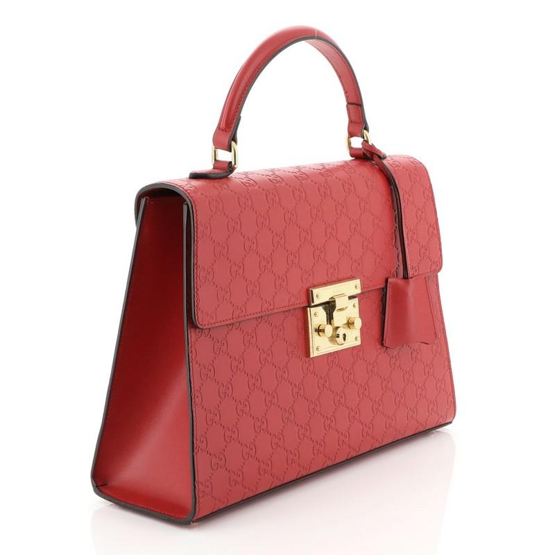 This Gucci Padlock Top Handle Bag Guccissima Leather Medium, crafted in red guccissima leather, features single loop leather handle and gold-tone hardware. Its S-lock closure opens to a neutral microfiber interior with zip and slip and pockets.