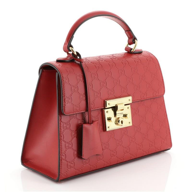 This Gucci Padlock Top Handle Bag Guccissima Leather Small, crafted in red guccissima leather, features single loop leather handle and gold-tone hardware. Its S-lock closure opens to a neutral microfiber interior with zip and slip and pockets.