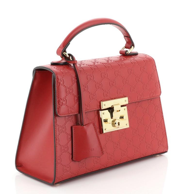 This Gucci Padlock Top Handle Bag Guccissima Leather Small, crafted in red guccissima leather, features single loop leather handle and gold-tone hardware. Its S-lock closure opens to a neutral microfiber interior with zip and slip and pockets.