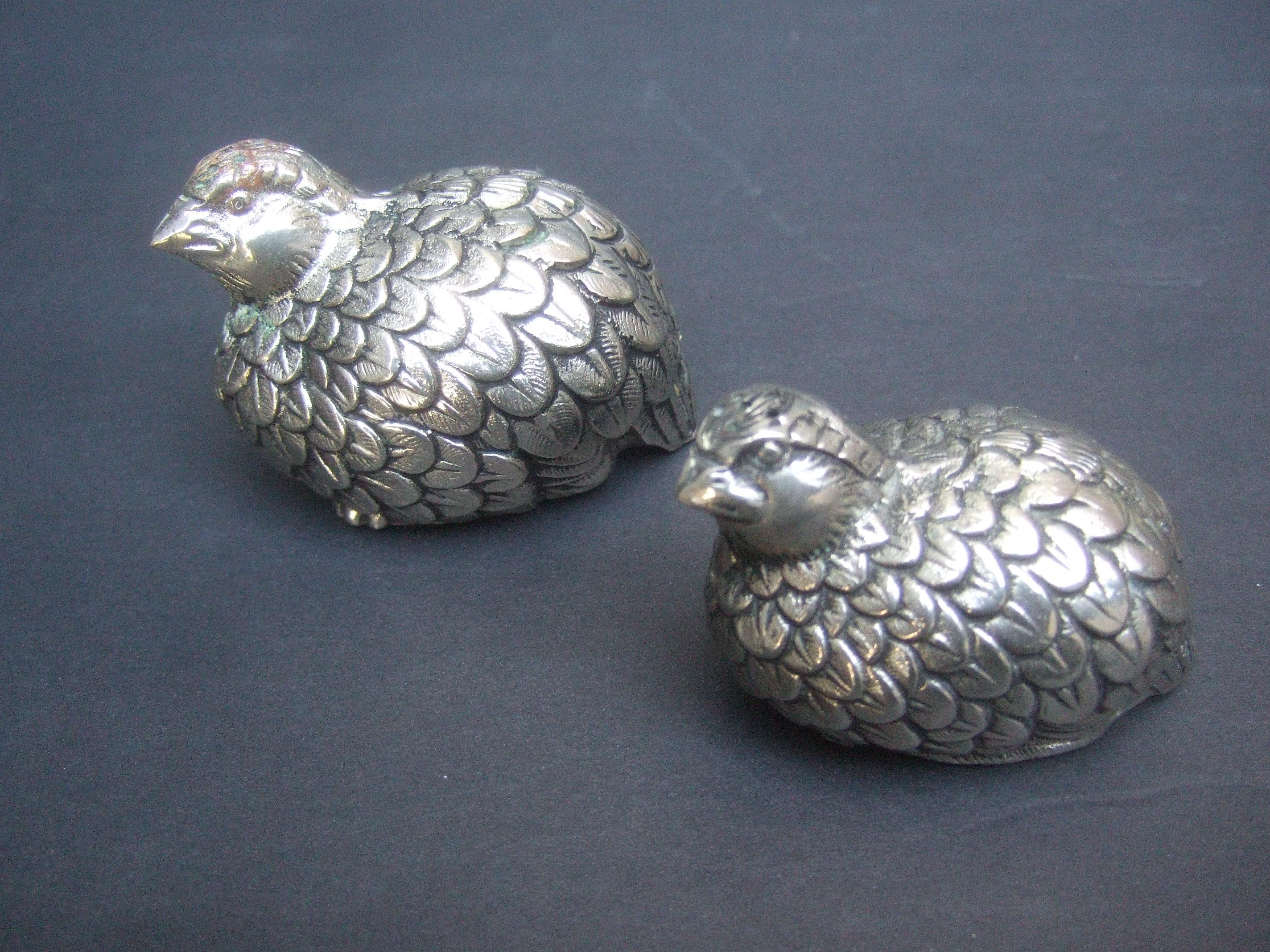 Gucci Itay Pair of silver metal quail salt & pepper shakers c 1970s
The elegant pair of stylized quails have textured detail that emulates their plumage  
The pair of Gucci quails are graduated in size 

The base of each figure is inscribed Gucci