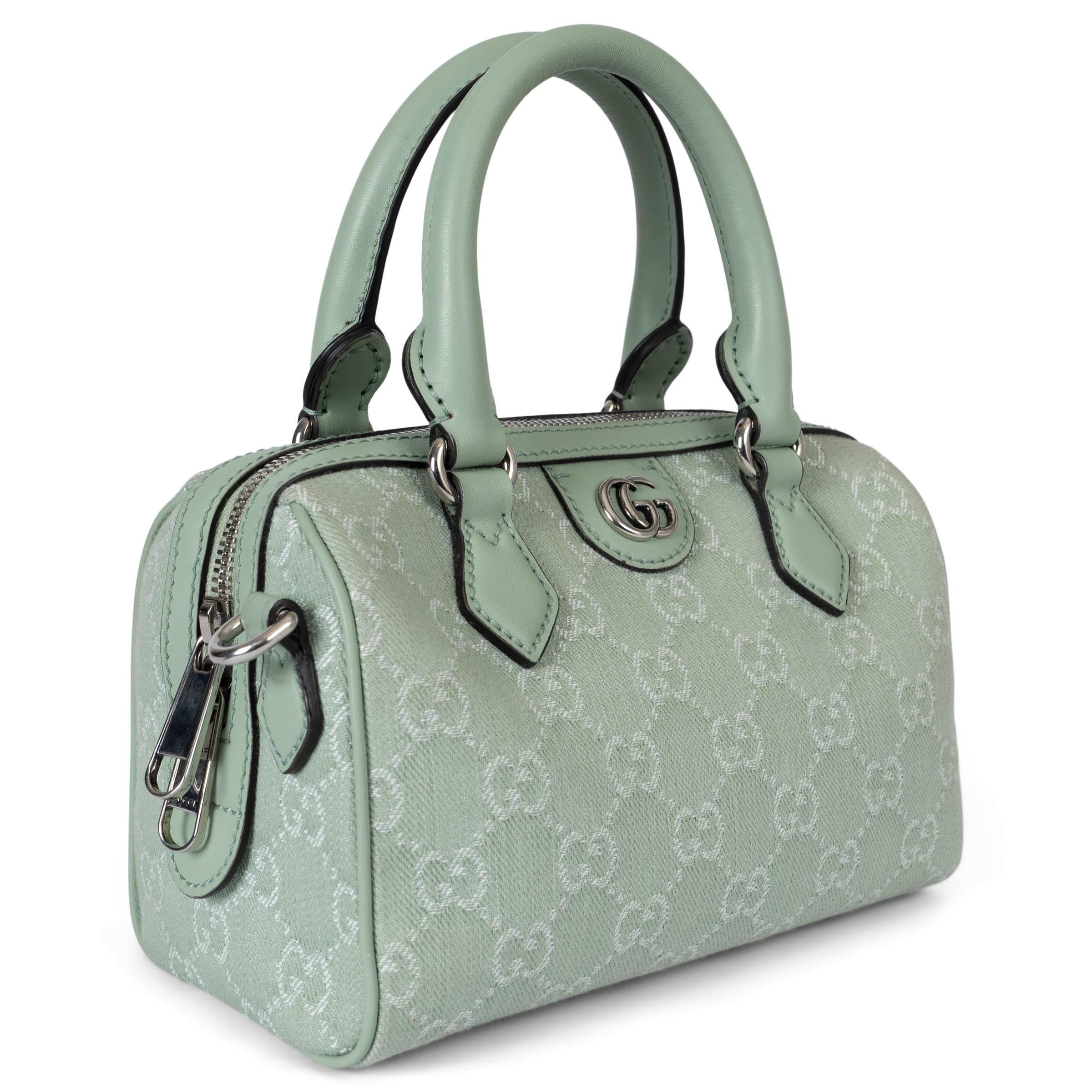 This 100% authentic Gucci Ophidia GG Mini top handle bag in pale green GG monogram denim exudes both elegance and playful charm. Enhanced with tonal leather trims and luxurious light-gold hardware, it offers a refined yet modern appeal. The
