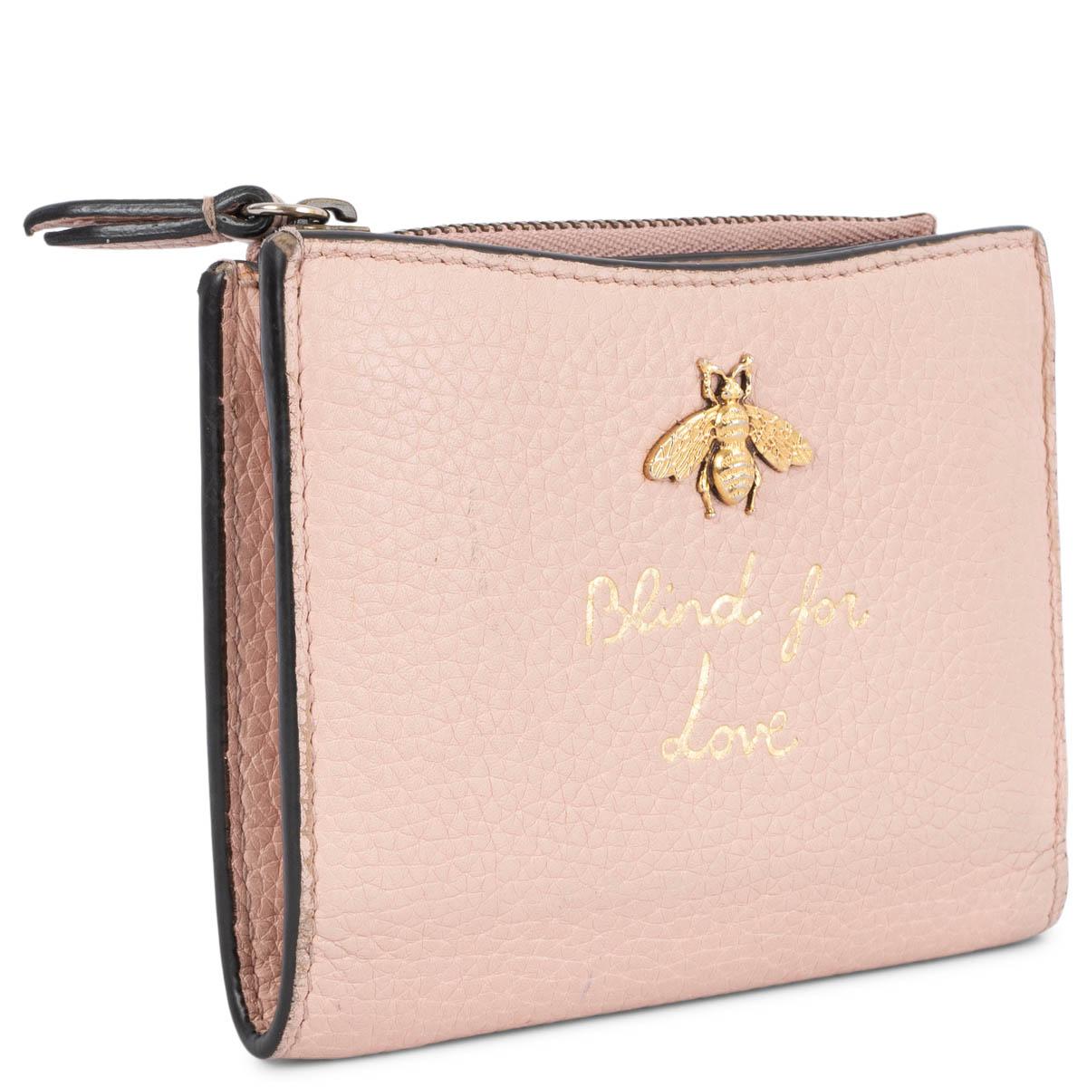 100% authentic Gucci Blind for Love small wallet in pebbled nude calfskin featuring gold-tone hardware. Opens with a push-button to six credit card slots, a bill compartment and five other small compartments plus a zipped coin pocket. The design