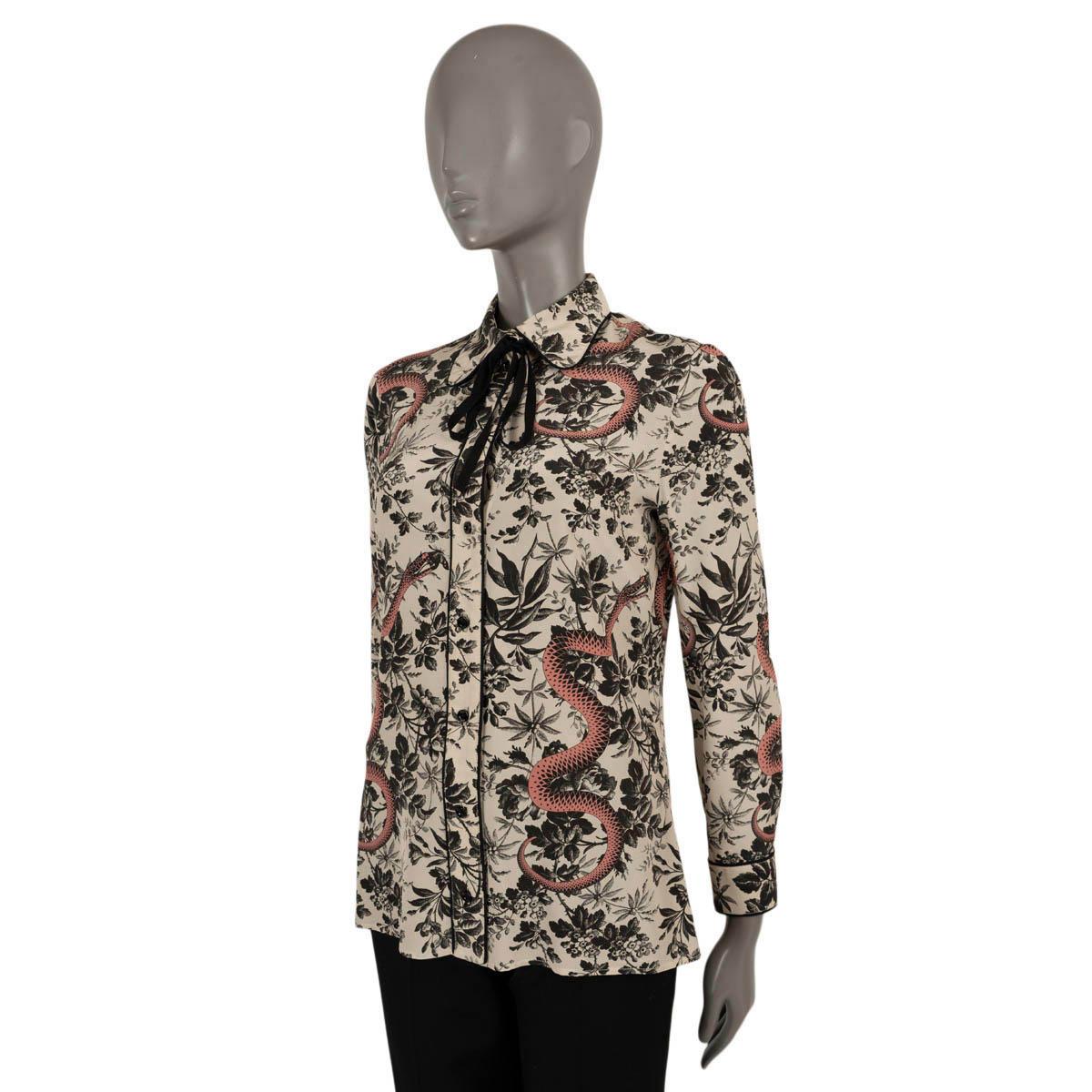 100% authentische Gucci Herbarium Snake Print Bluse aus blassrosa Kreppseide (100% - bitte beachten Sie, dass das Inhaltsetikett fehlt). Mit schwarzem Blumendruck, rosa Schlangen und schwarzen Paspeln. Wird mit Knöpfen auf der Vorderseite