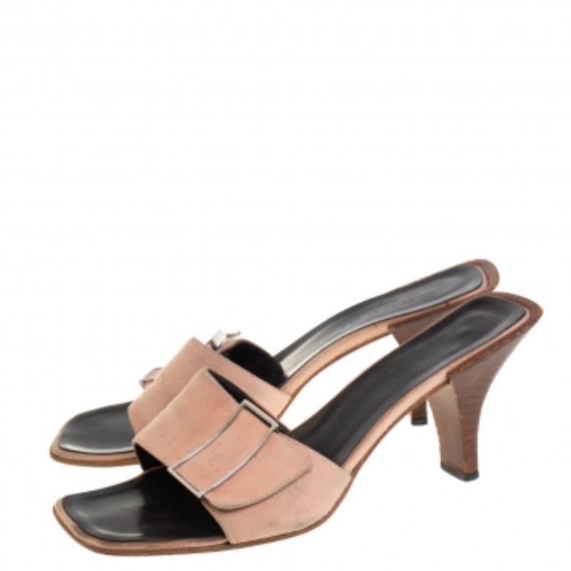 These pink slide sandals by Gucci are classic. Crafted from suede, they feature the brand label and metal detailing on the vamps along with leather-lined insoles that carry brand labeling. They are elevated on 8.5 cm tall heels. These slides are