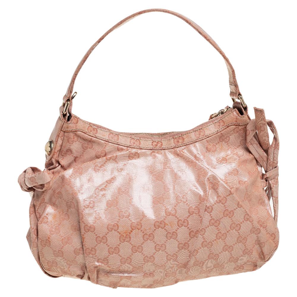 This peach-hued Gucci hobo is one you don’t want to miss out on. The exterior is made from crystal GG crystal canvas and accented with gold-tone hardware, a round Gucci charm, and signature Horsebit detail. This hobo features a single handle, web