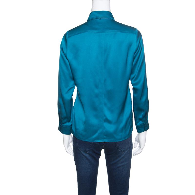 Isn't this shirt from Gucci just wonderful! The peacock blue shirt is made of 100% silk and features a simple structured silhouette. It flaunts collars with a satin ribbon tie detailing, front button fastenings and long sleeves. Pair it with denims