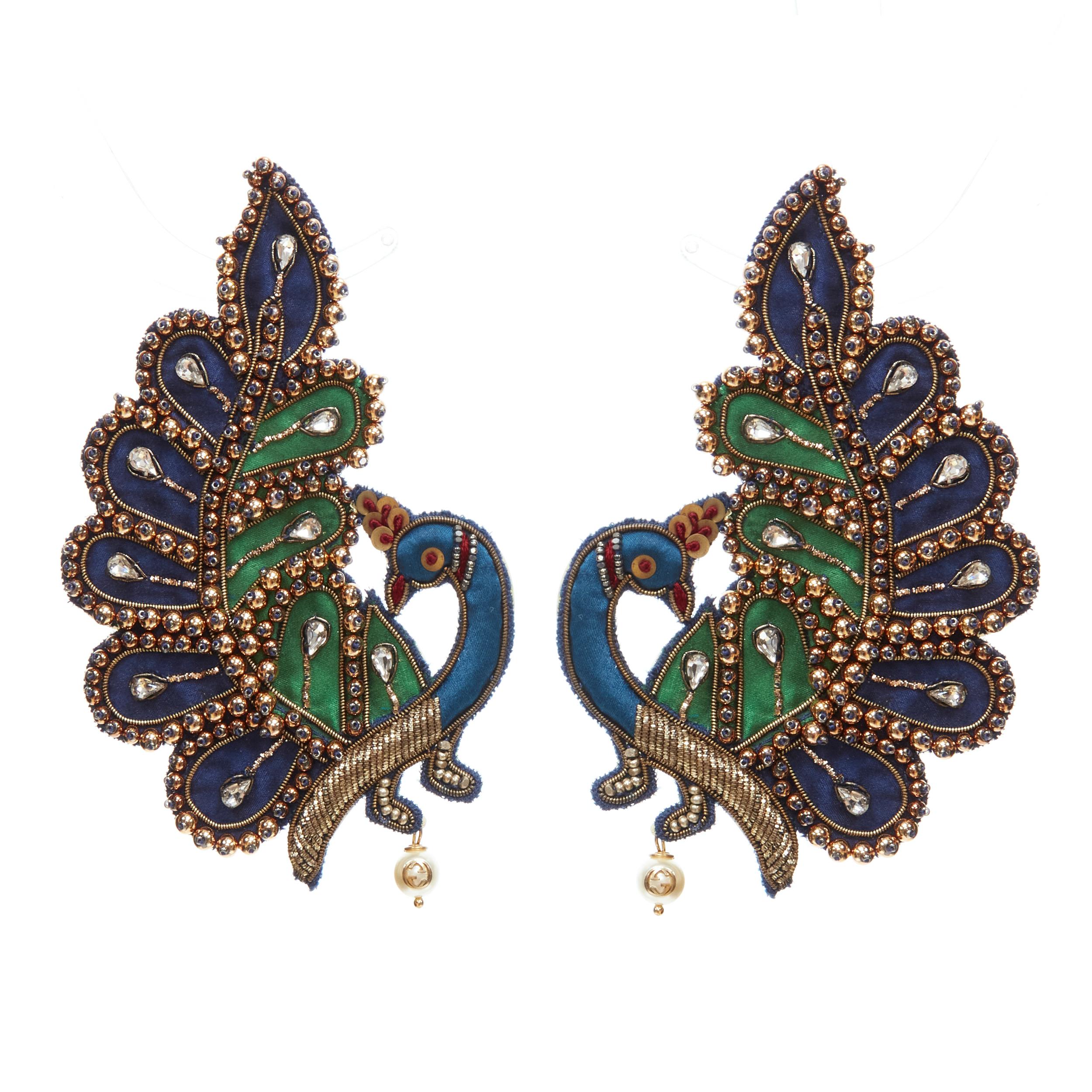 GUCCI Peacock crystal rhinestone bead embellished GG pearl clip on earring 
Reference: TGAS/C00940 
Brand: Gucci 
Designer: Alessandro Michele 
Material: Acrylic 
Color: Blue 
Closure: Clip ON 
Extra Detail: Peacock fabric design with gold-tone bead