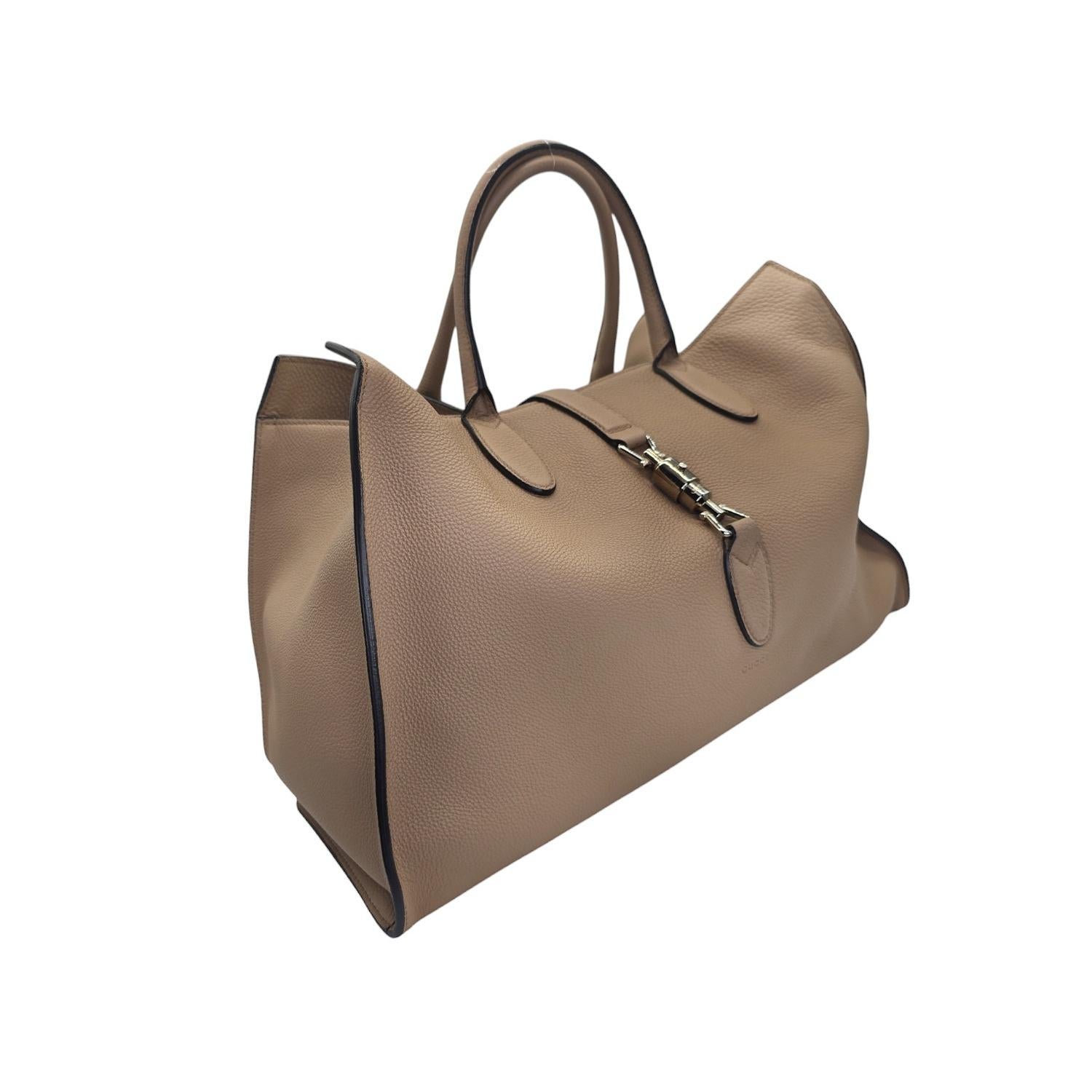 Die Gucci Jackie Soft Leather Top Handle Bag strahlt Luxus und Raffinesse aus. Diese in Italien aus geschmeidigem Kalbsleder gefertigte Tasche verfügt über den ikonischen Kolbenriemenverschluss und ein geräumiges Innenfach aus beigem Wildleder mit