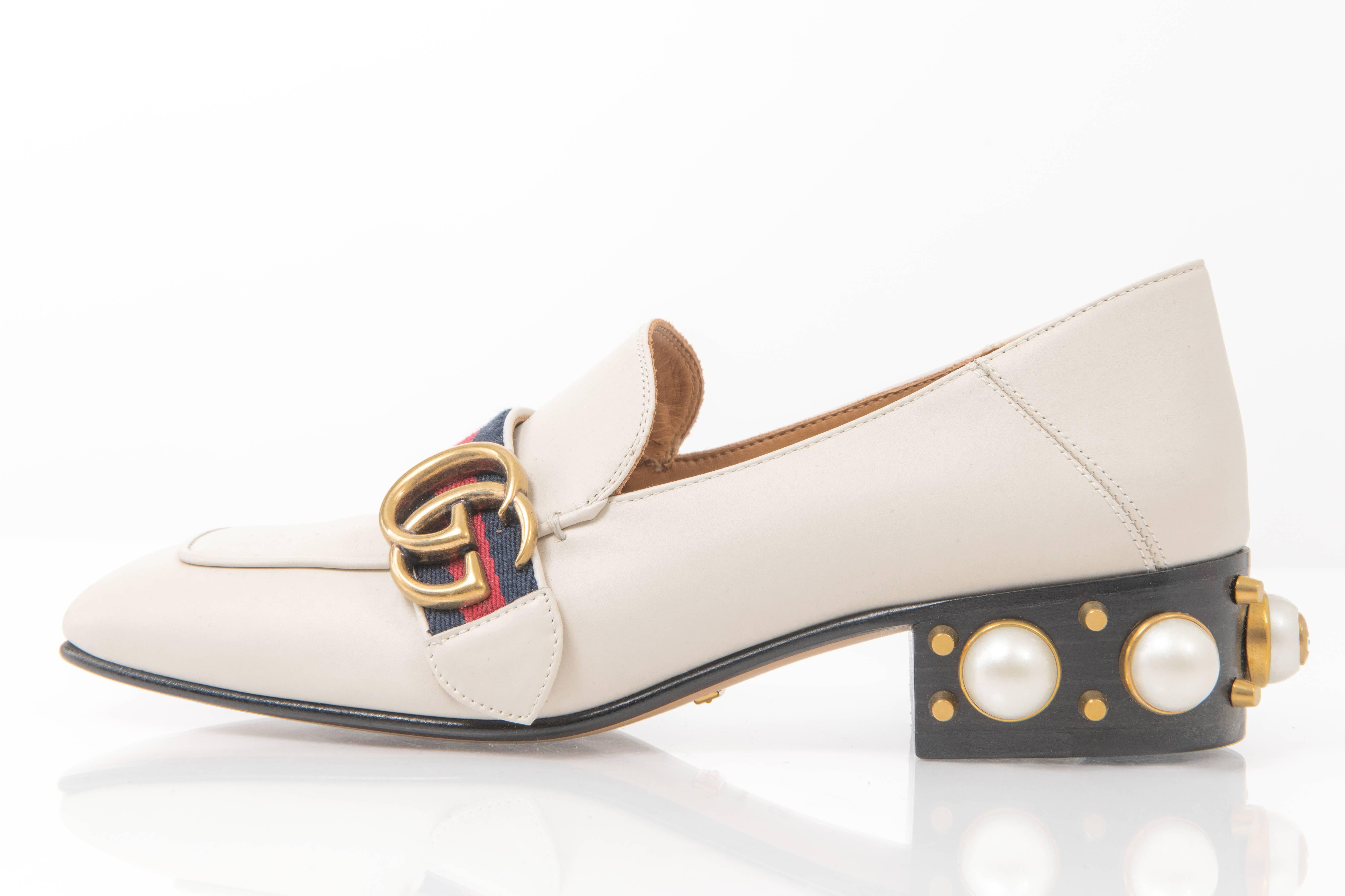 Gucci Peyton Ivory Loafer.  Current season at Gucci retailing at $1370 CAD. Low wood heel, square toe, faux pearl stud logo detail, navy and red web stripe, and GG logo.  Marked size 36.5 (USA 6).  Collapsible back so can be worn as a slide or slip
