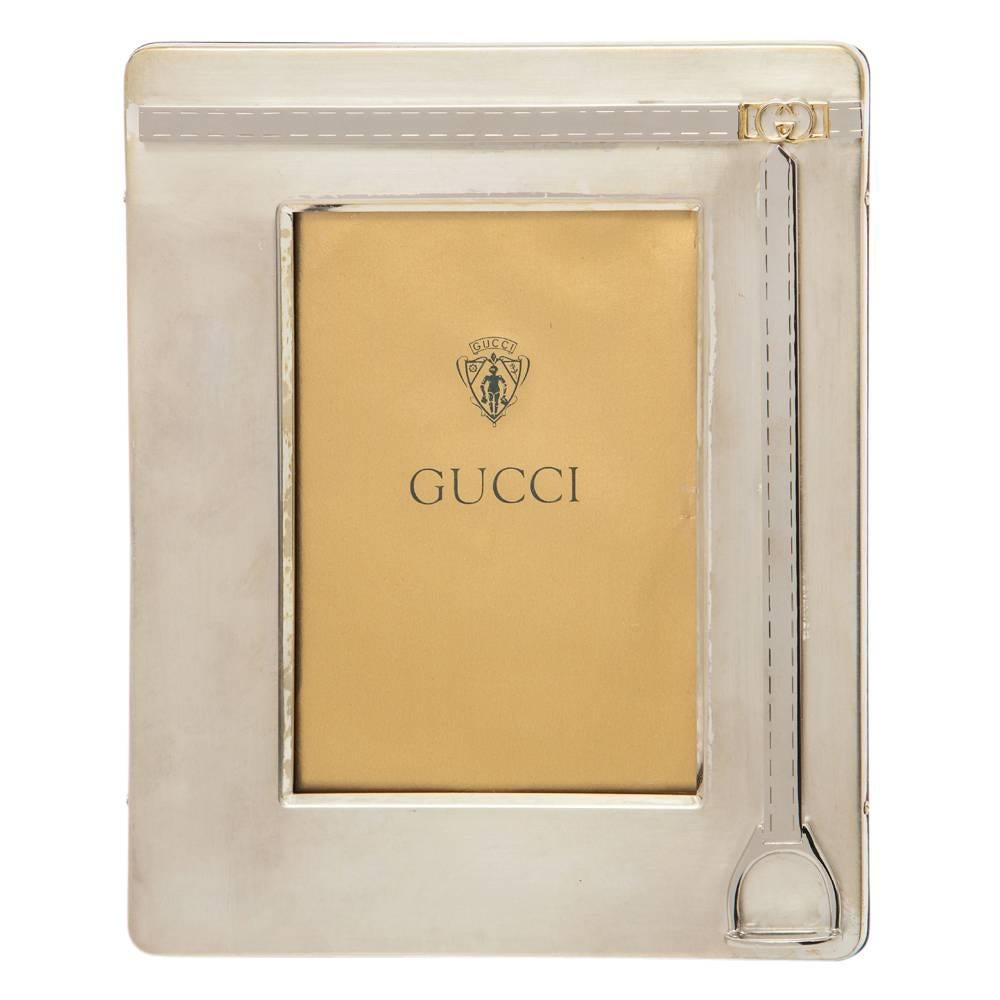 Gucci stirrup picture frame, silver plate and brass, signed. Small to medium scale equestrian themed photo frame with brass interlocking GG in upper right and stirrup decoration in lower right. Metal label of back of the frame which reads: Gucci
