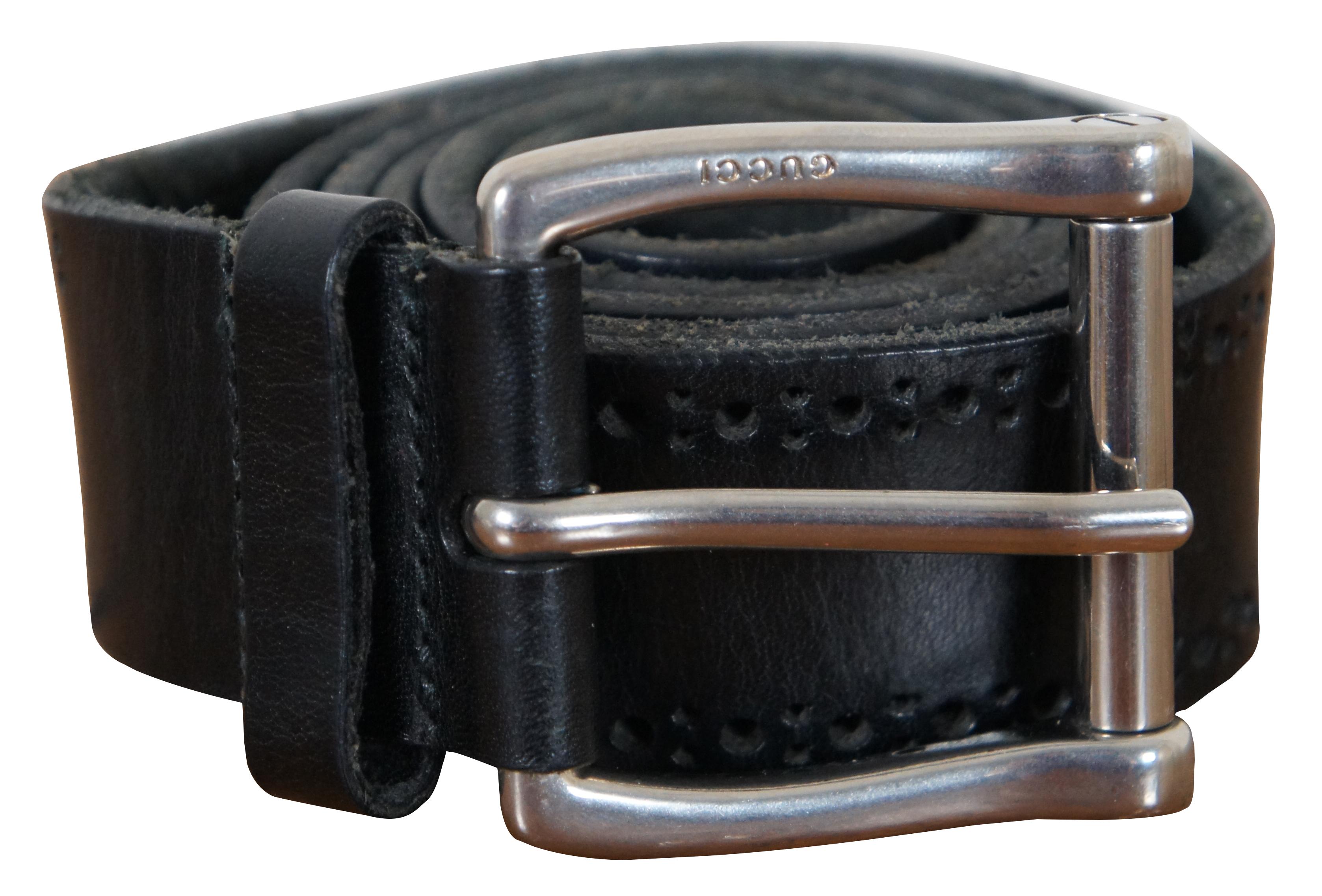 Gucci black leather mens belt featuring a pierced design along the edge and squared off silver tone buckle; serial number 302972214351100.

Size 40 / Total Length – 46.75” x 1.5” / Buckle - 2.125” x 2.25” / Fits Waists - 37