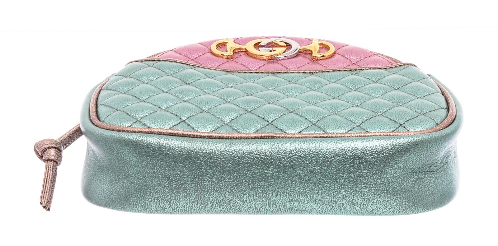 Gucci Mini Trapuntata crossbody bag crafted of textured calfskin leather in laminated pink and blue. The shoulder bag features a waist length braided shoulder strap and has combined its horse bit and interlocked G insignias in gold and silver tone
