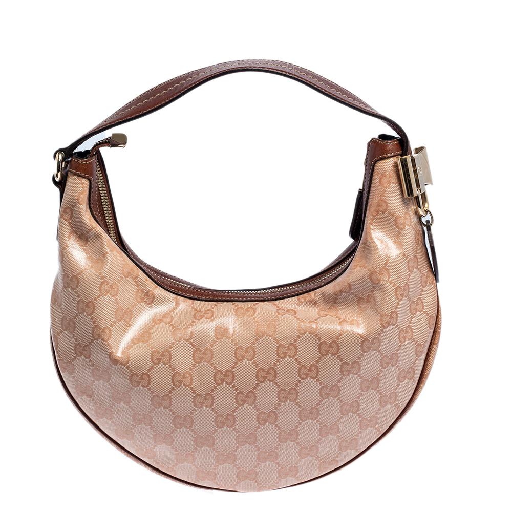 This Duchessa bag by Gucci is crafted from GG crystal coated canvas as well as leather and styled with a metal bow detail on the side. It features a leather handle, and the top zip closure opens to a spacious fabric-lined interior to house your