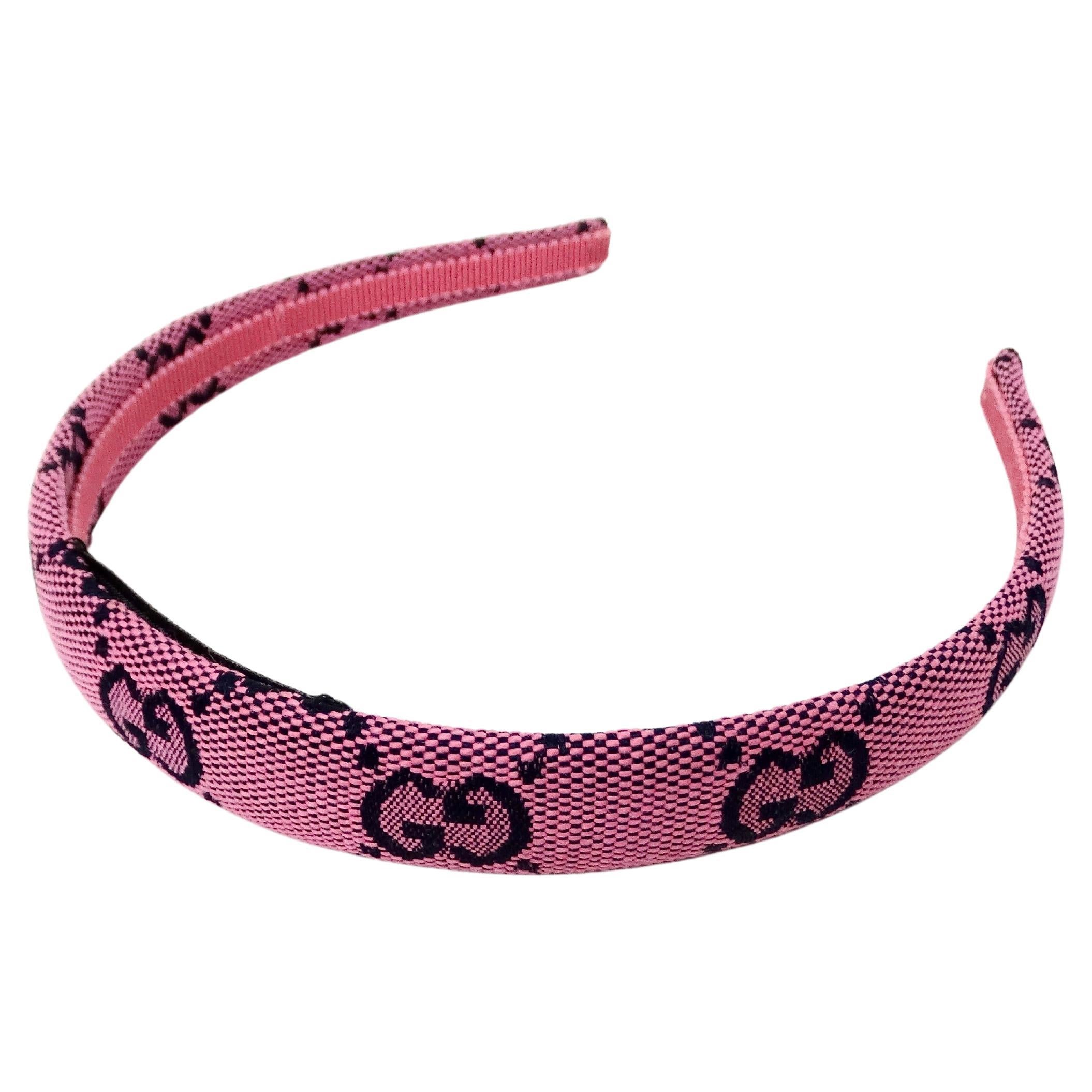 The Gucci Pink GG Monogram Canvas Headband is a vibrant and stylish accessory that embodies the brand’s signature luxury aesthetic. Crafted from high-quality canvas, this headband features the iconic GG monogram pattern in a playful pink hue, making