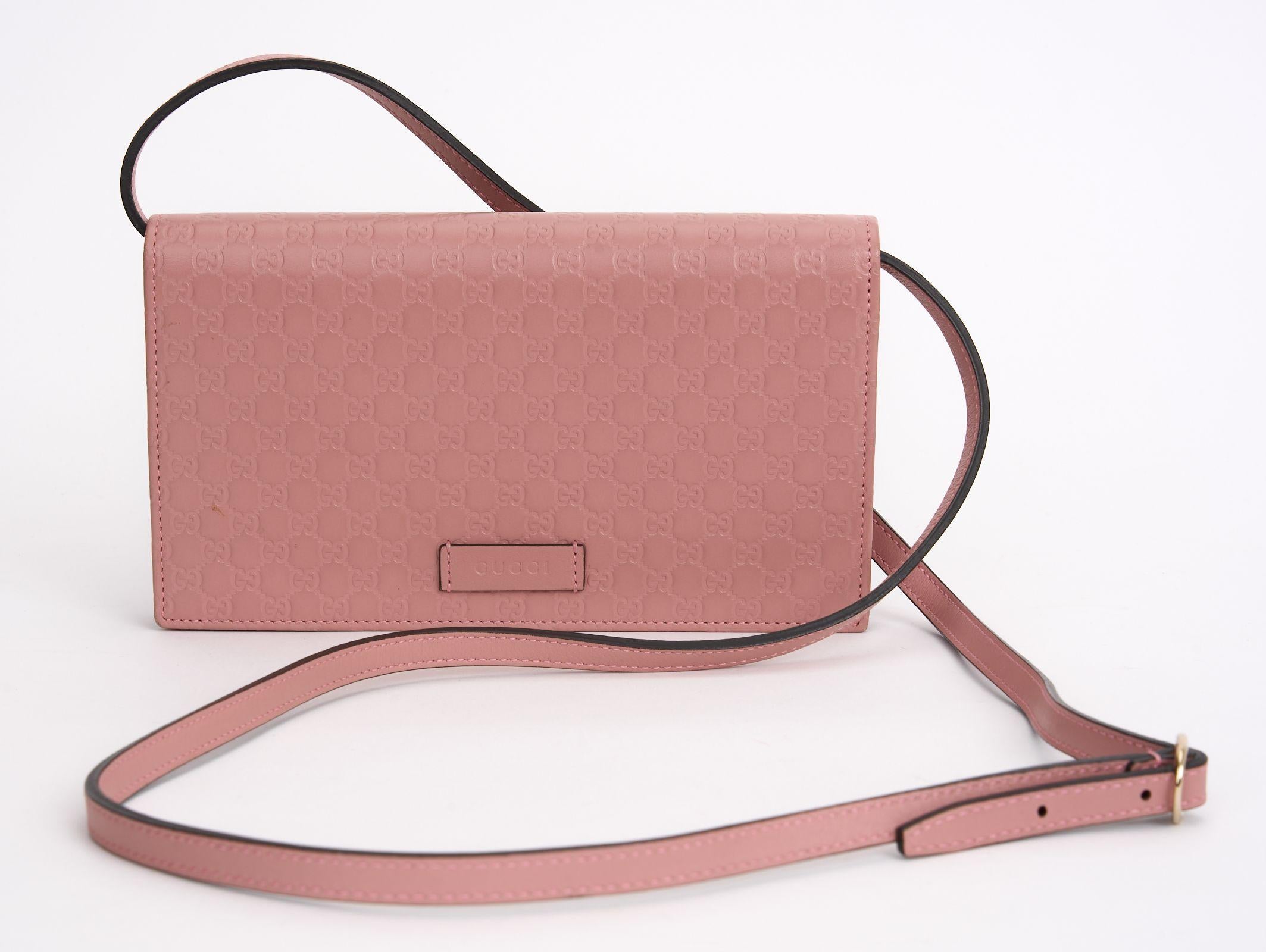 This Gucci Microguccissima Wallet On Strap and Crossbody Bag features Pink Leather with a 
Microguccissima Pattern and gold hardware, a single adjustable shoulder strap, leather lining interior pockets with card slots and a snap closure at front.