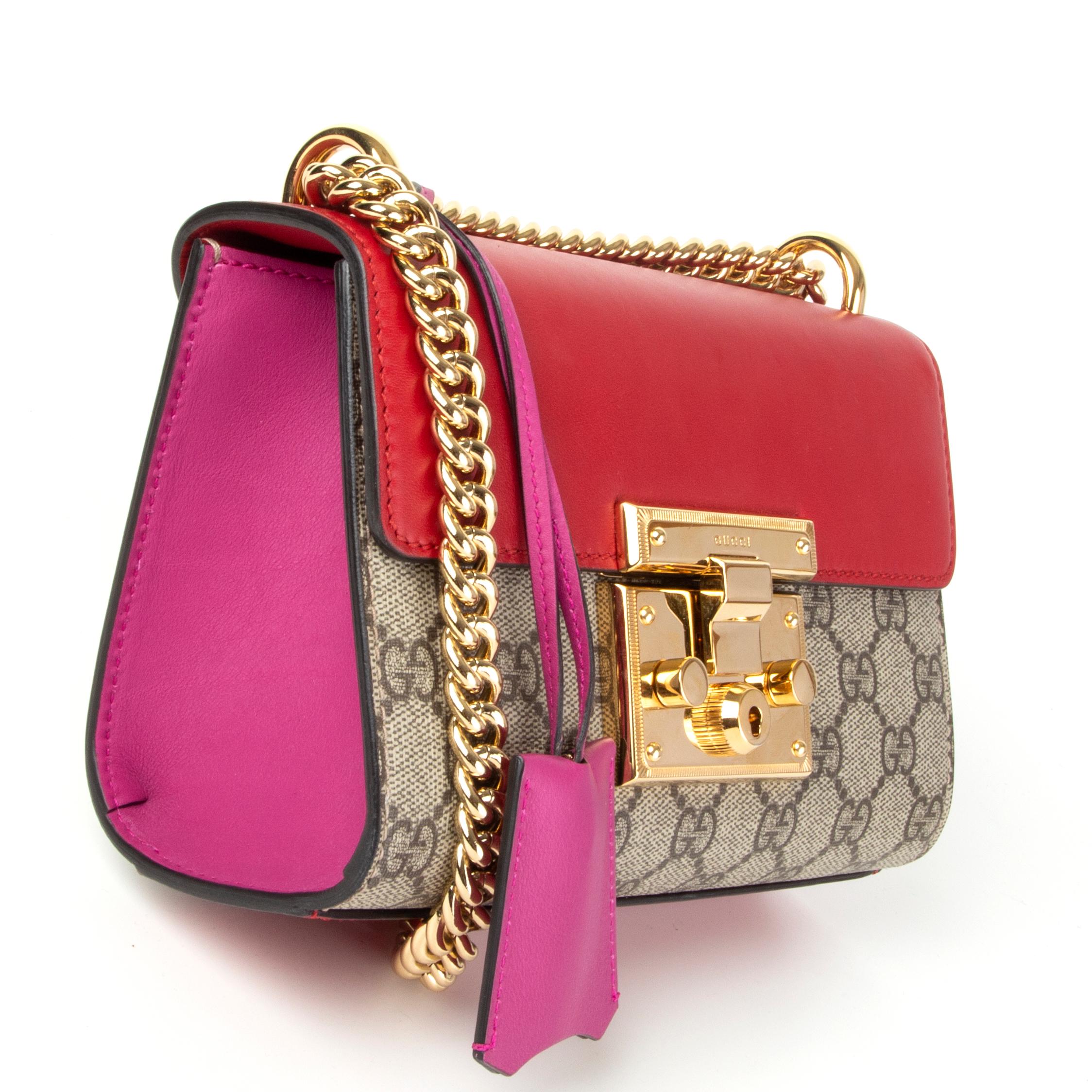 Gucci 'Padlock Small' shoulder bag in hibiscus and pink calfskin featuring beige GG Supreme monogram canvas front and back with a open pocket on the back side. Gold-tone hardware and chain shoulder strap. Lined in tan microfibre with one open pocket