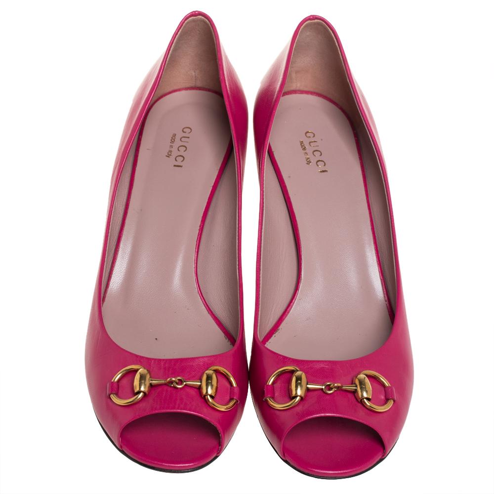 Featuring a chic, minimalist design, these pumps from Gucci are easy to style. Pink leather uppers showcase the signature Horsebit in gold-tone metal. Kitten heels and peep toes form a distinctive outline. Their simple design pairs equally well with