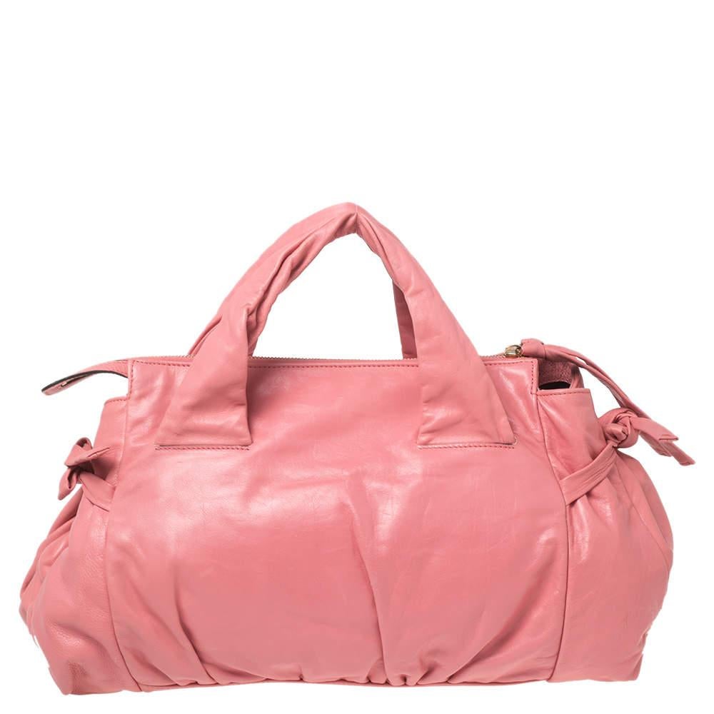 This Gucci Hysteria bag is built for everyday use. Crafted in Italy, it is made from leather and comes in a pink hue. It has ties on the sides and dual handles for you to parade it. The nylon interior is spacious and is secured with zip closure. The