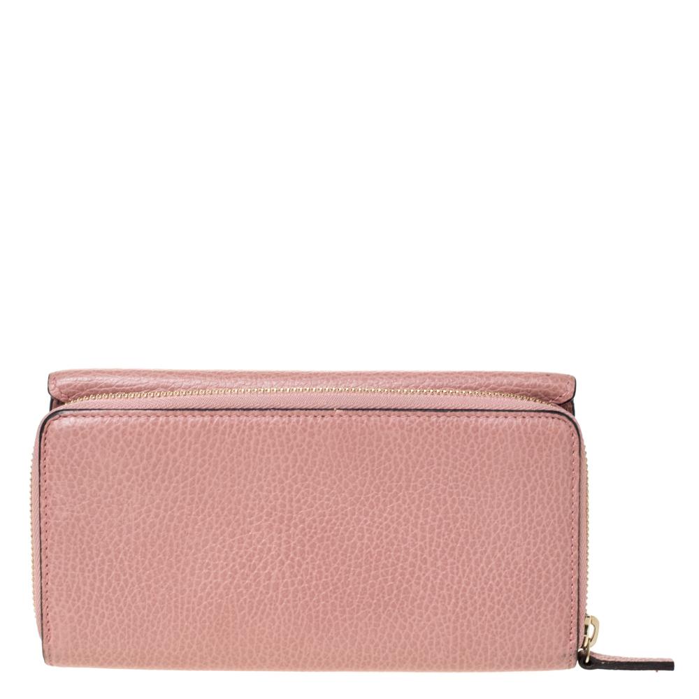 Bringing a fine mix of fashion and fine craftsmanship is this continental wallet from Gucci. The wallet comes crafted from pink leather and designed with a front flap, multiple card slots, and a zip compartment. The GG logo in gold-tone completes