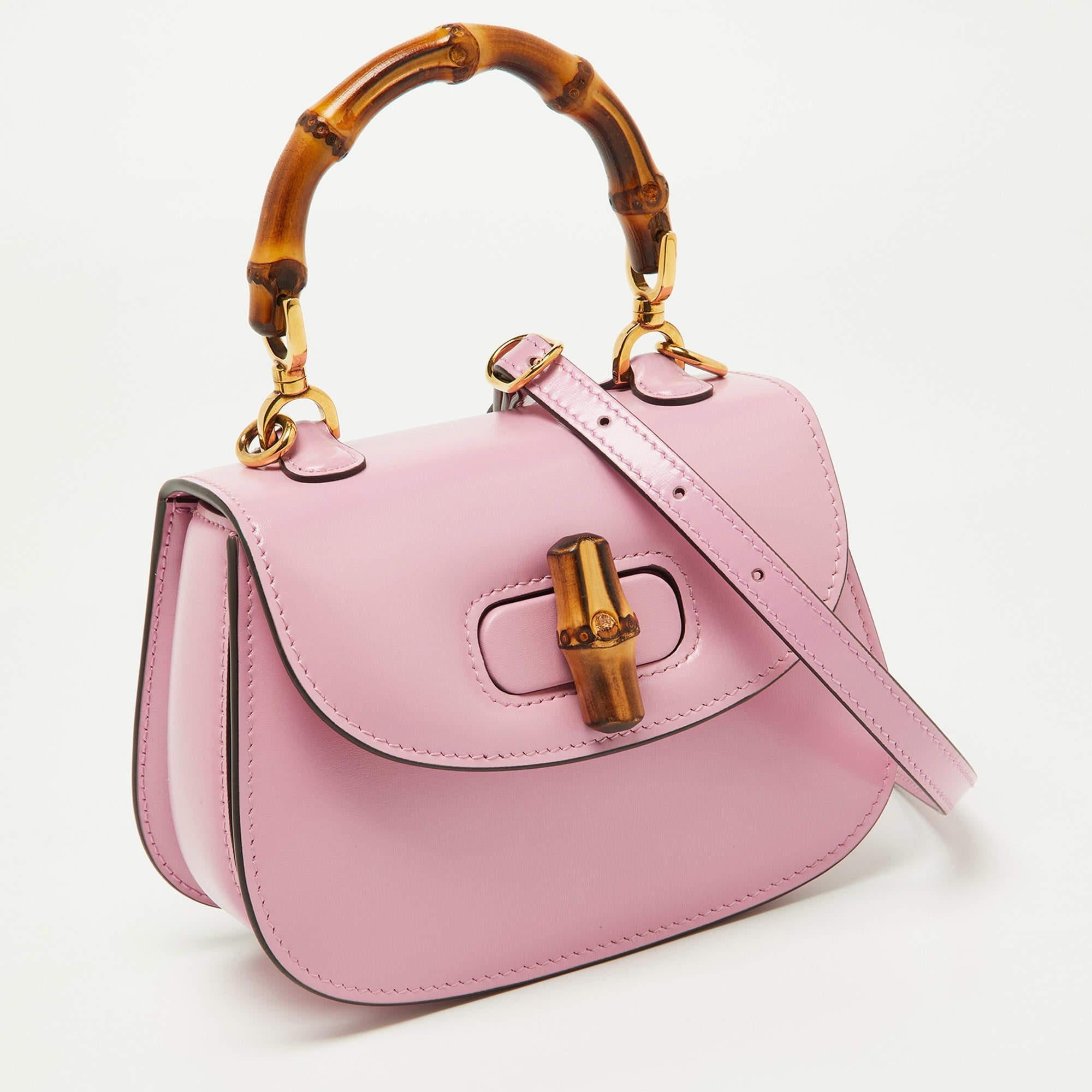 Crafted with elegance and sophistication, the Gucci Top Handle Bag epitomizes timeless style. Its supple pink leather exudes luxury, while the iconic bamboo top handle adds a touch of exotic charm. Compact yet functional, it seamlessly blends