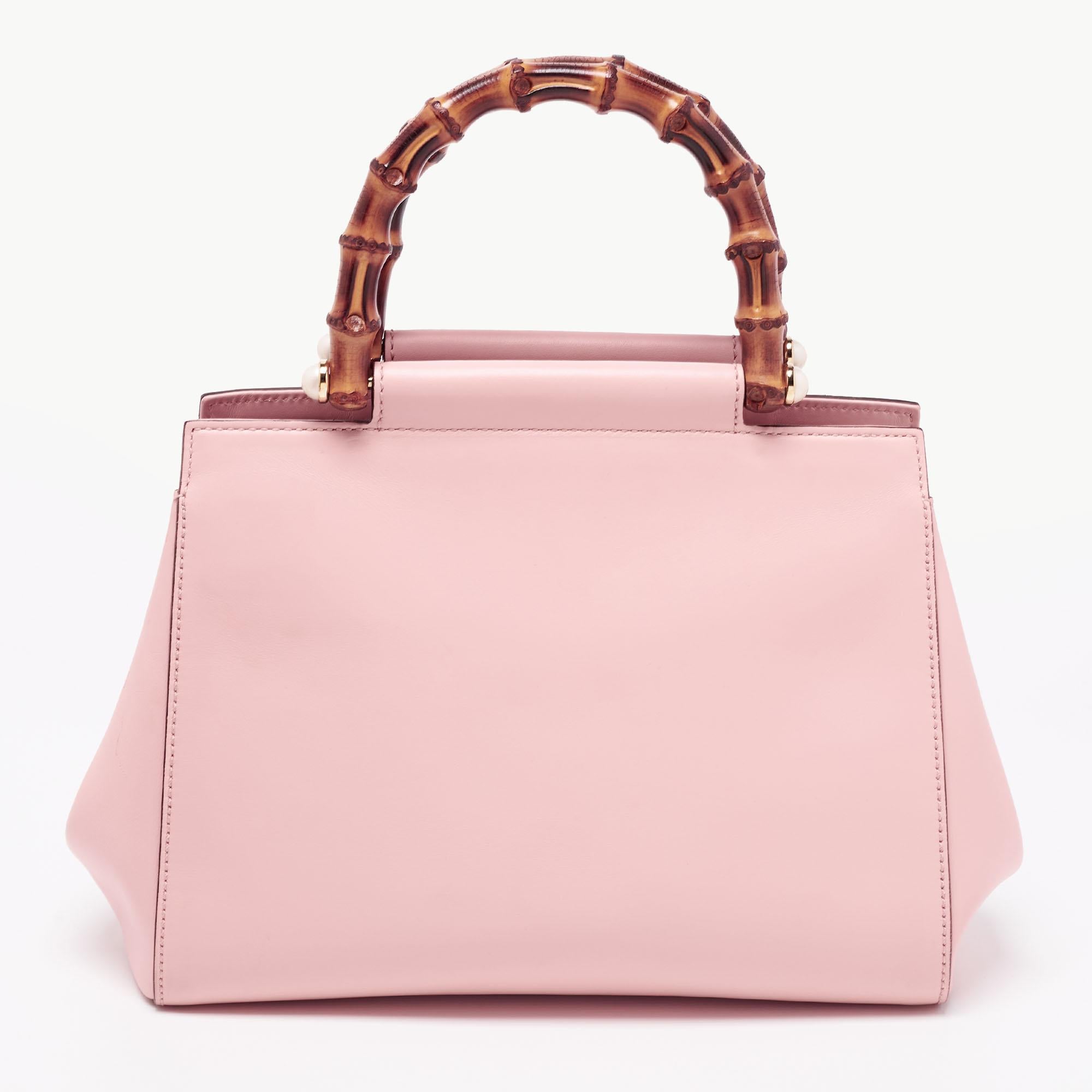 This gorgeous Gucci tote is an example of contemporary design. Look elegant and fashionable with this chic pink bag which is styled with bamboo handles featuring pearl details on each side. Crafted in leather and lined with Alcantara on the inside,