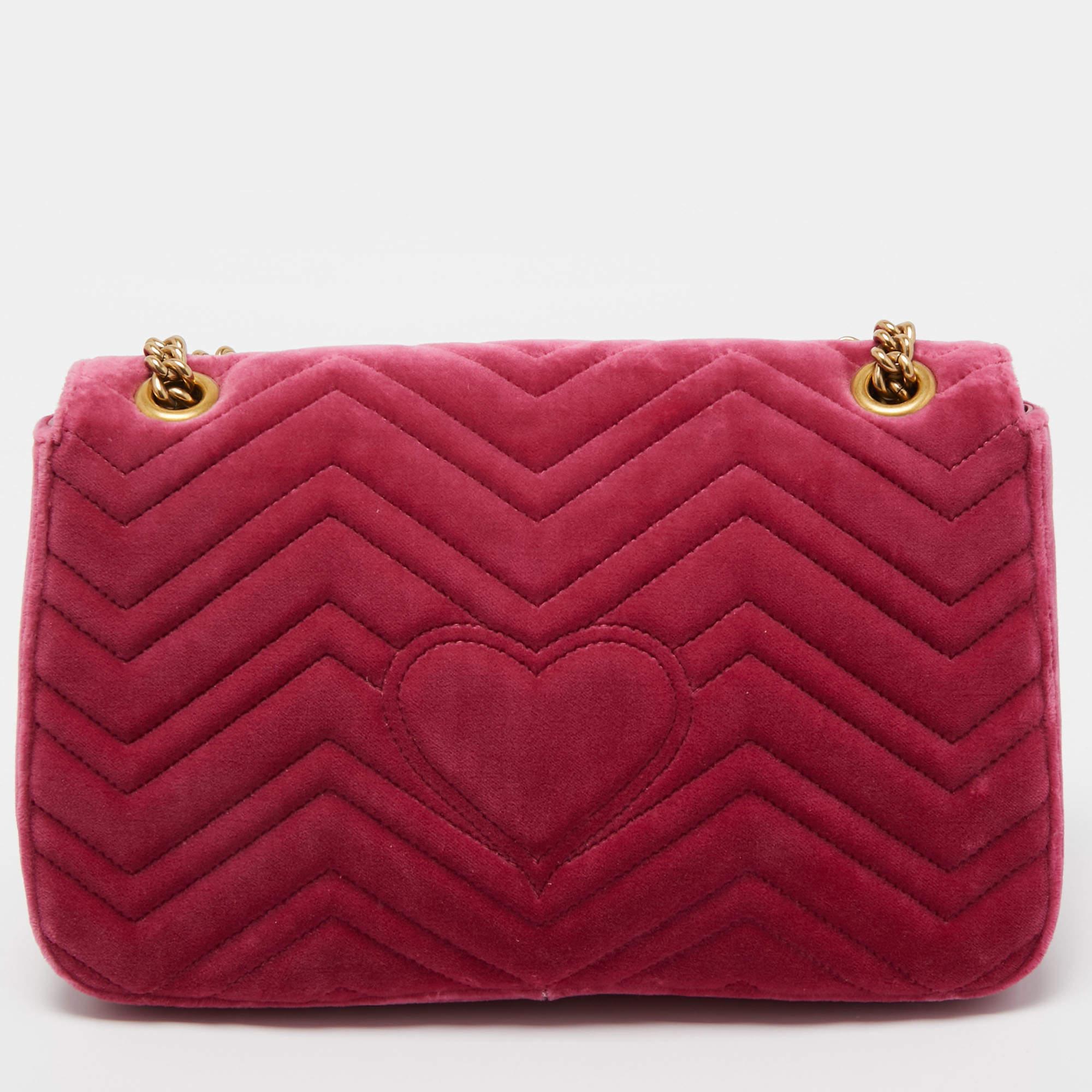 The Marmont bag has been exquisitely crafted from pink velvet and equipped with a well-sized satin-leather interior. On the front, there is a GG logo on the flap, 'BLIND FOR LOVE' in pearls, and floral embroidery, along with a shoulder strap