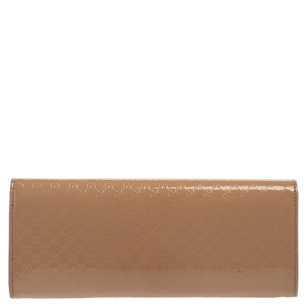 A must-have for all Gucci lovers! This Broadway clutch is crafted from patent leather with microguccissima embossing and is provided with gold-tone hardware. The flap closure with concealed magnetic fastening secures its leather and suede-lined