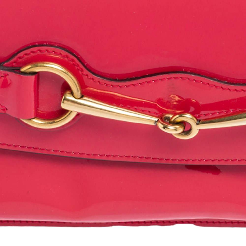 Gucci brings you yet another gorgeous accessory with this clutch. It has been carefully crafted from patent leather into a simple shape and a pink hue. The front flap featuring the signature Horsebit opens to reveal a canvas interior for your