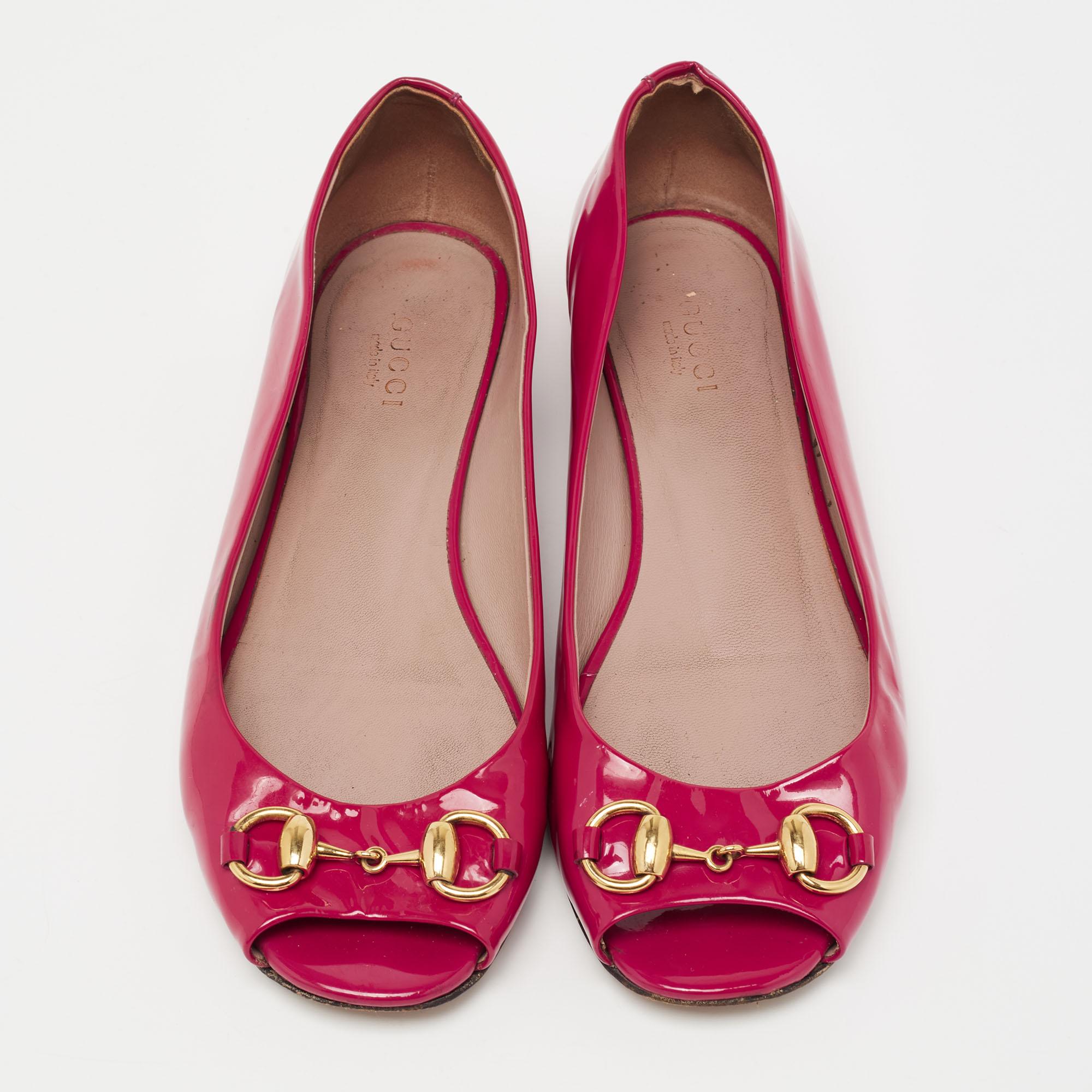 The sculptural silhouette of these Gucci ballet flats gets a signature update with the Horsebit motif on the open toes. Created from patent leather, they exhibit a slip-on fitting, gold-tone hardware, and low heels.

