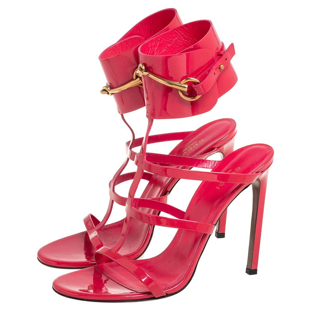 These Ursula sandals from the House of Gucci are stylish, minimalistic, and sleek. They are made from pink patent leather, which is enriched by a gold-toned Horsebit motif on the ankle strap. They feature gold-toned fittings, open-toes, and pointy