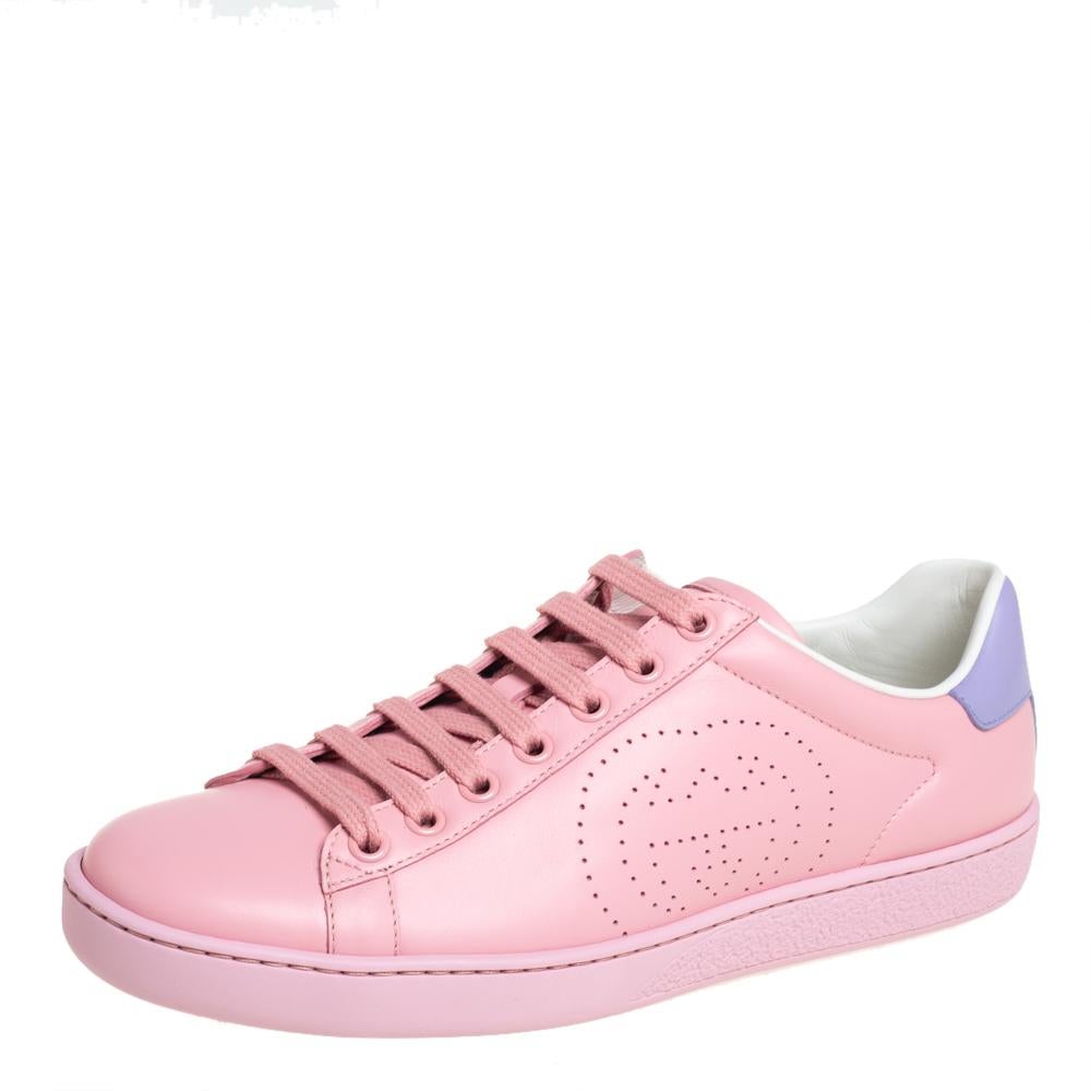 Das mit charakteristischen Details versehene Gucci-Paar ist aus Leder gefertigt und verfügt über einen tiefen Ausschnitt und eine Schnürung am Schaft. Die rosafarbenen und lilafarbenen Sneaker sind an den Seiten mit perforierten GG-Logodetails