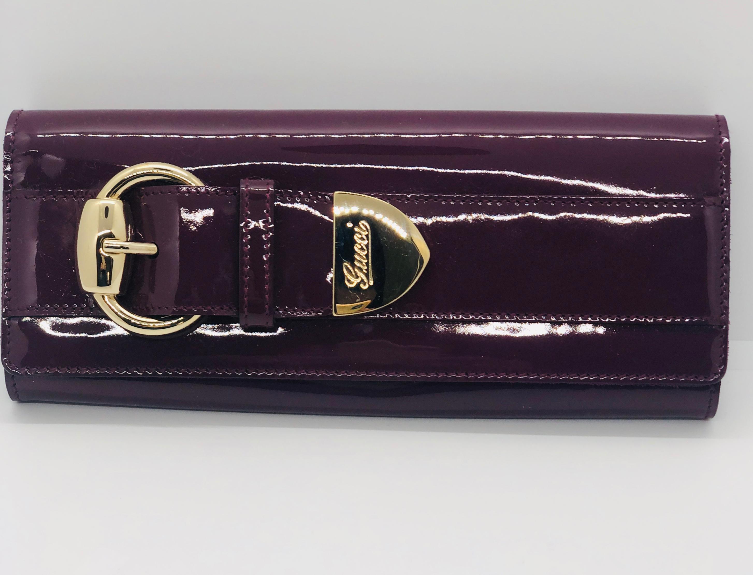Offered is a Gucci pink / purple patent leather mini clutch with gold metal insignia hardware.

Make:  Gucci
Place of manufacture:  Italy
Color:  Berry- pink / purple
Style:  Mini patent leather clutch with gold metal hardware / Retro print silk