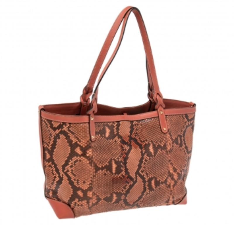 Carry this ever-stylish bag from the house of Gucci to your next social event. It features a python leather body with two handles and a matching pouch. It has a capacious interior for all your essentials. It can easily be matched with most of your