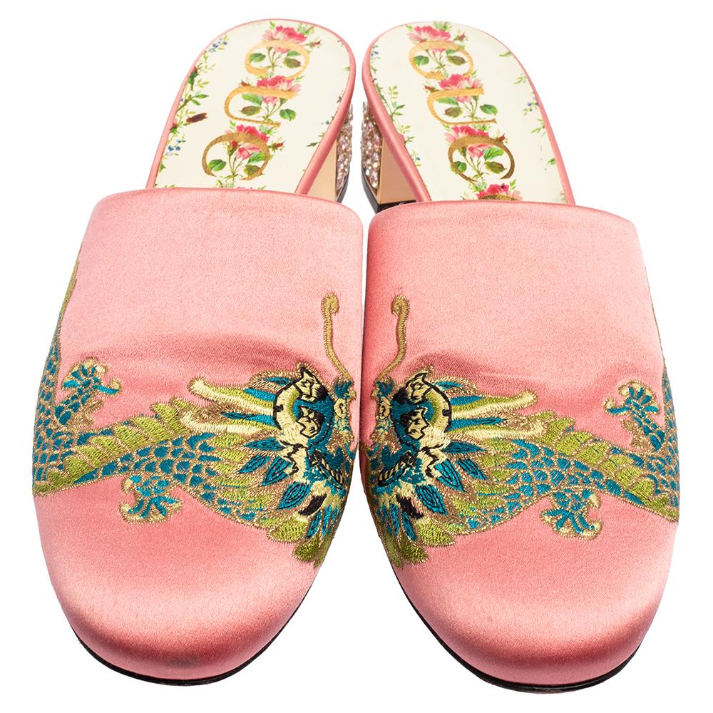 These Gucci mules will make a grand addition to your closet. These shoes are enhanced by a pretty embroidery on the vamps. Featuring a plush satin body and embellished heels, these pink mules are a note on modern sophistication.

