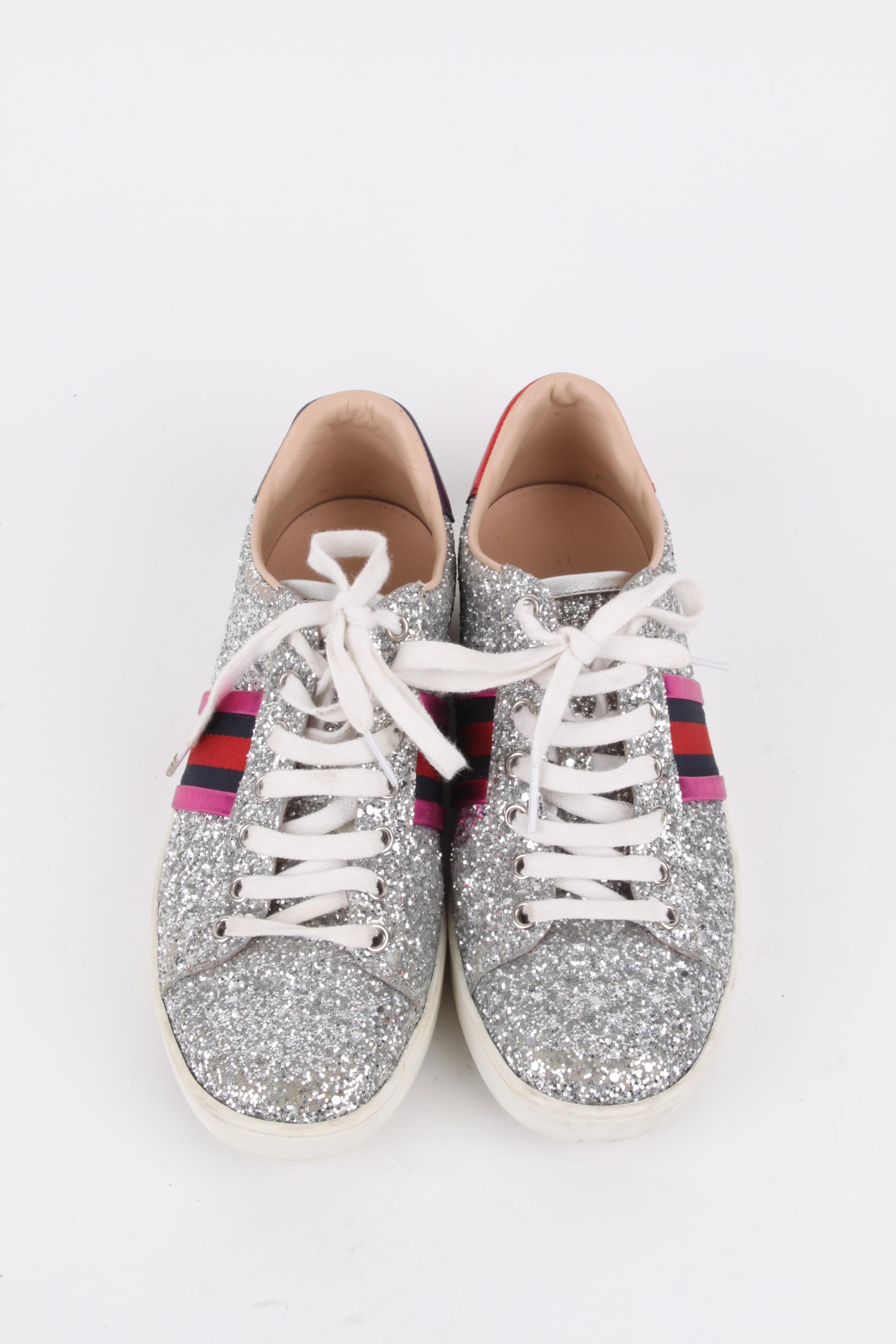 Gucci Pink Silver Glitter Ace Web Detail Sneaker.

Ace Gucci Sneakers with a sporty-chic design. This model represents a remarkable innovation of high class and originality by the Maison. A bright upper is embellished with a glittering surface with