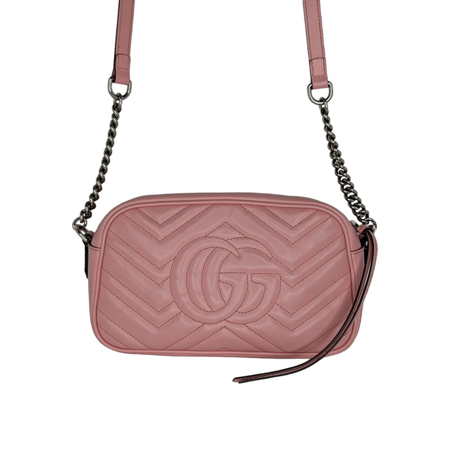 The small GG Marmont chain shoulder bag has a softly structured shape and a zip top closure with the Double G hardware. The chain shoulder strap has a leather shoulder detail. The camera bag is made in matelassé leather with a chevron design and GG