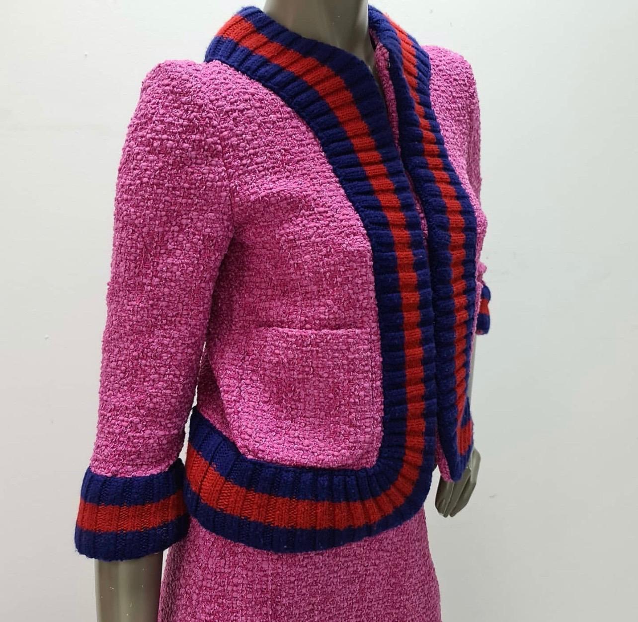From the 2016 Collection. Pink, red and navy Gucci tweed skirt suit. Jacket features Web rib knit trim throughout, three-quarter sleeves, dual patch pockets at sides and concealed hook closures at front. Skirt features Web rib knit trim at waist and
