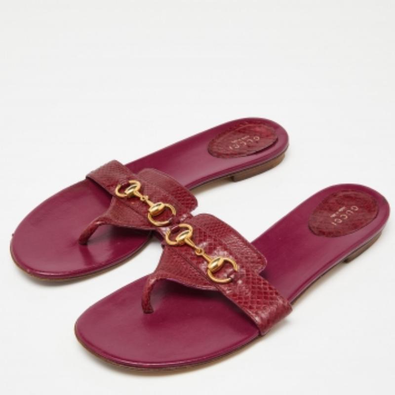 Diese flachen Sandalen von Gucci sind aus Wasserschlangenleder gefertigt und mit dem Horsebit-Motiv versehen. Das offene Design sorgt dafür, dass man leicht in sie hineinschlüpfen kann. Diese rosafarbenen Zehenstegsandalen sind ein tolles Accessoire