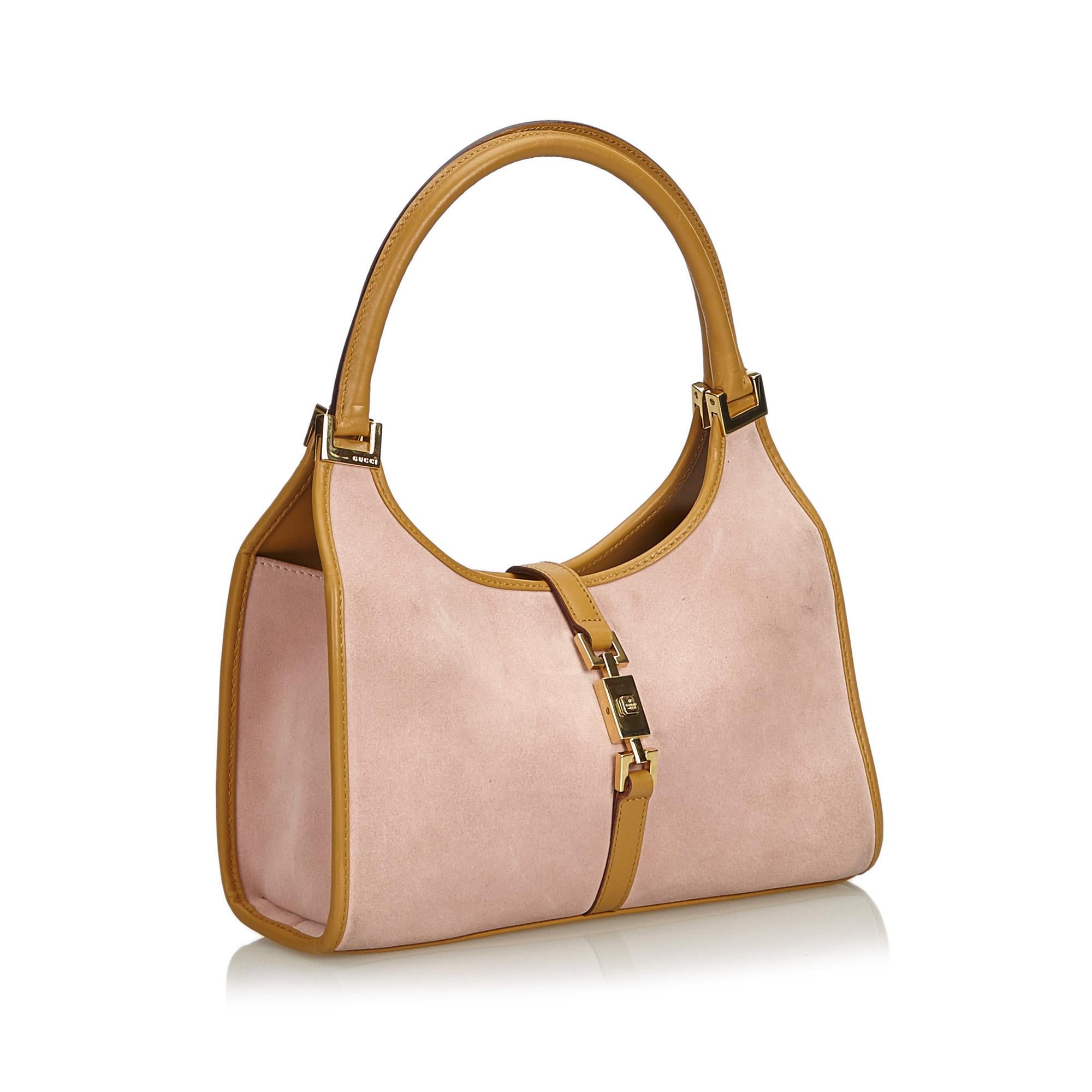This Jackie features a suede body with leather trim, rolled leather handles, an open top with flat leather strap and push lock closure, and an interior zip pocket. It carries as B condition rating.

Inclusions: 
Dust Bag

Dimensions:
Length: 19.00