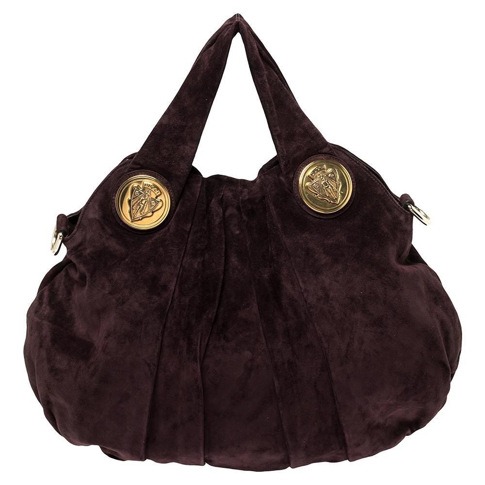 This Gucci hobo is built for everyday use. Crafted from plush suede, it has a plum-hued exterior and two handles for you to easily parade it. The nylon insides are sized well and the Hysteria hobo is complete with the signature emblems.

Includes: