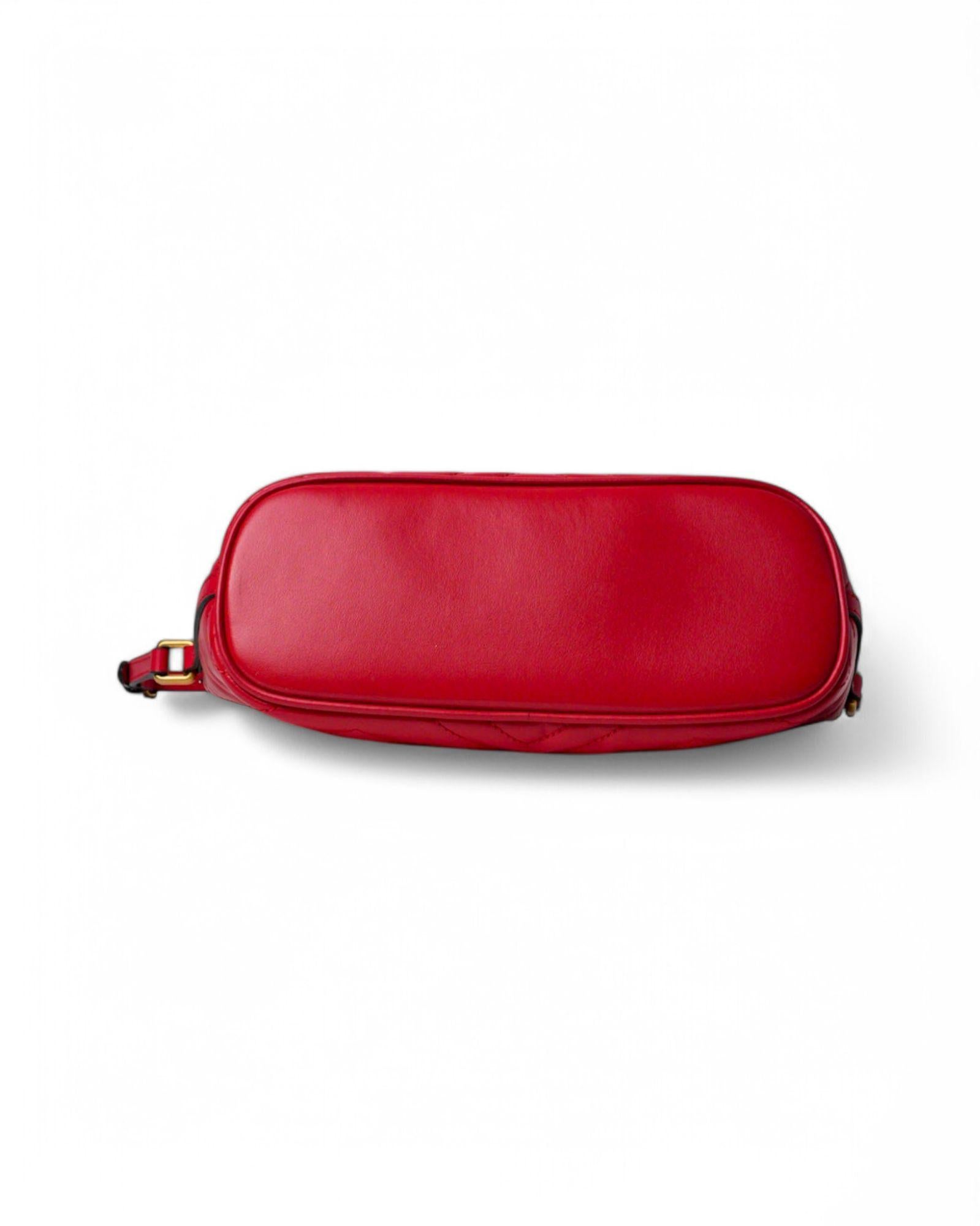 Borsa firmata Gucci della linea Marmont, modello Hobo, realizzata in pregiata pelle matelassé di colore rosso con dettagli in hardware dorato. La chiusura superiore a zip offre sicurezza, mentre l’interno è foderato in tessuto scamosciato beige con