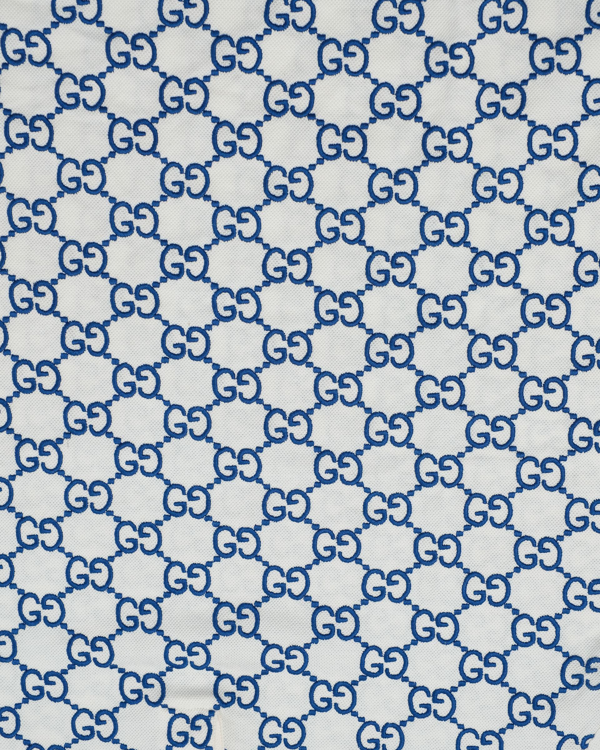 Polo firmata Gucci, modello Stretch, taglia L, realizzata in cotone piquet elasticizzata bianca e blu. Dotata di colletto a righe blu e rosse e munita di 3 bottoni centrali. L’articolo si presenta in ottime