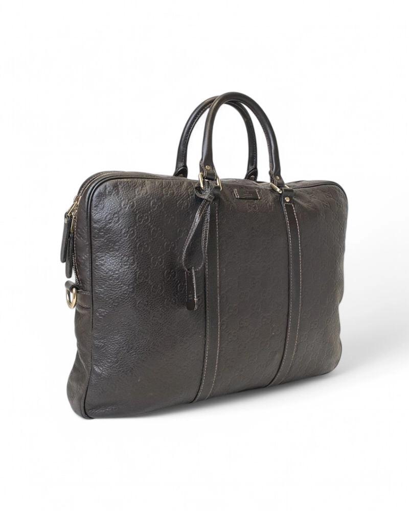 Signature Gucci briefcase made of brown leather in the GG Supreme pattern and gold hardware. Equipped with a semi-circular double-slider zipper closure, internally lined with black logo fabric with convenient pocket, quite roomy. Equipped with