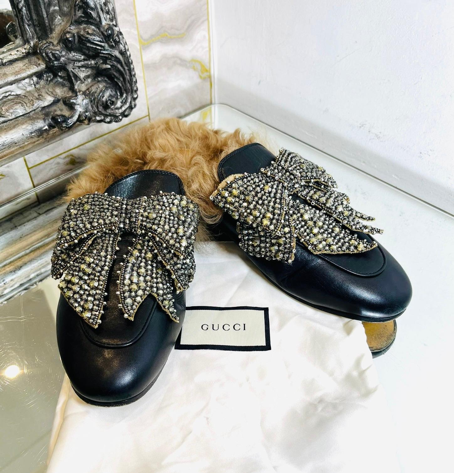 Gucci Princetown Crystal Bow & Shearling-Lined Leather Mules

Black mules designed with oversized bead and crystal embellished bow.

Featuring lamb shearling lining, round toe and leather soles and midsoles.

Rrp Approx. £1350

Size – 40

Condition